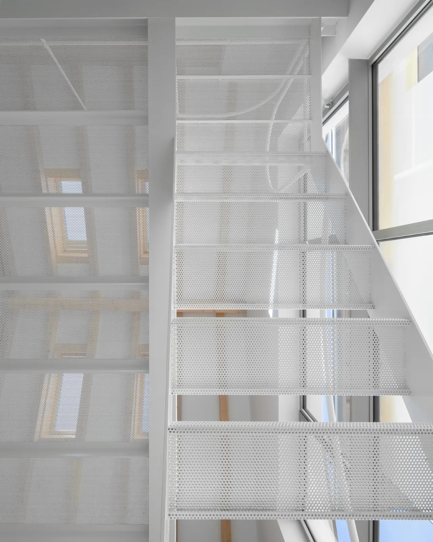 '009_Blue Bird Kitchen' by Studio Tropicana — Perforated metal screening dominates this interior passage, creating a layered transparency throughout the vertical void.
