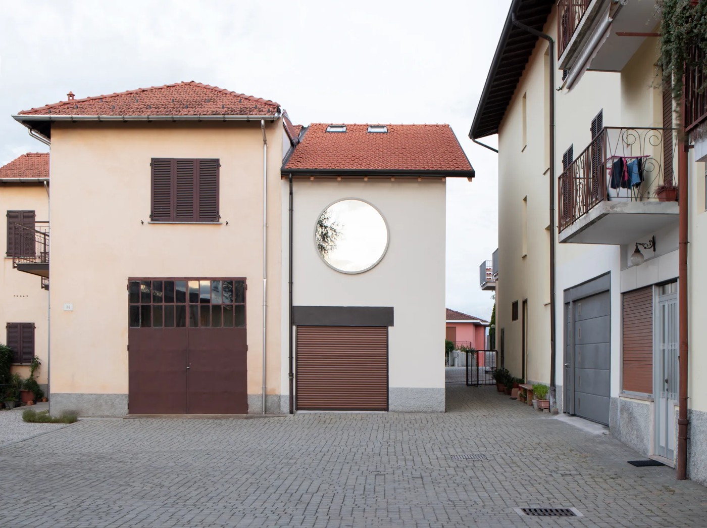 '009_Blue Bird Kitchen' by Studio Tropicana — A courtyard facade in Varese displays a composed arrangement of residential and utility structures.