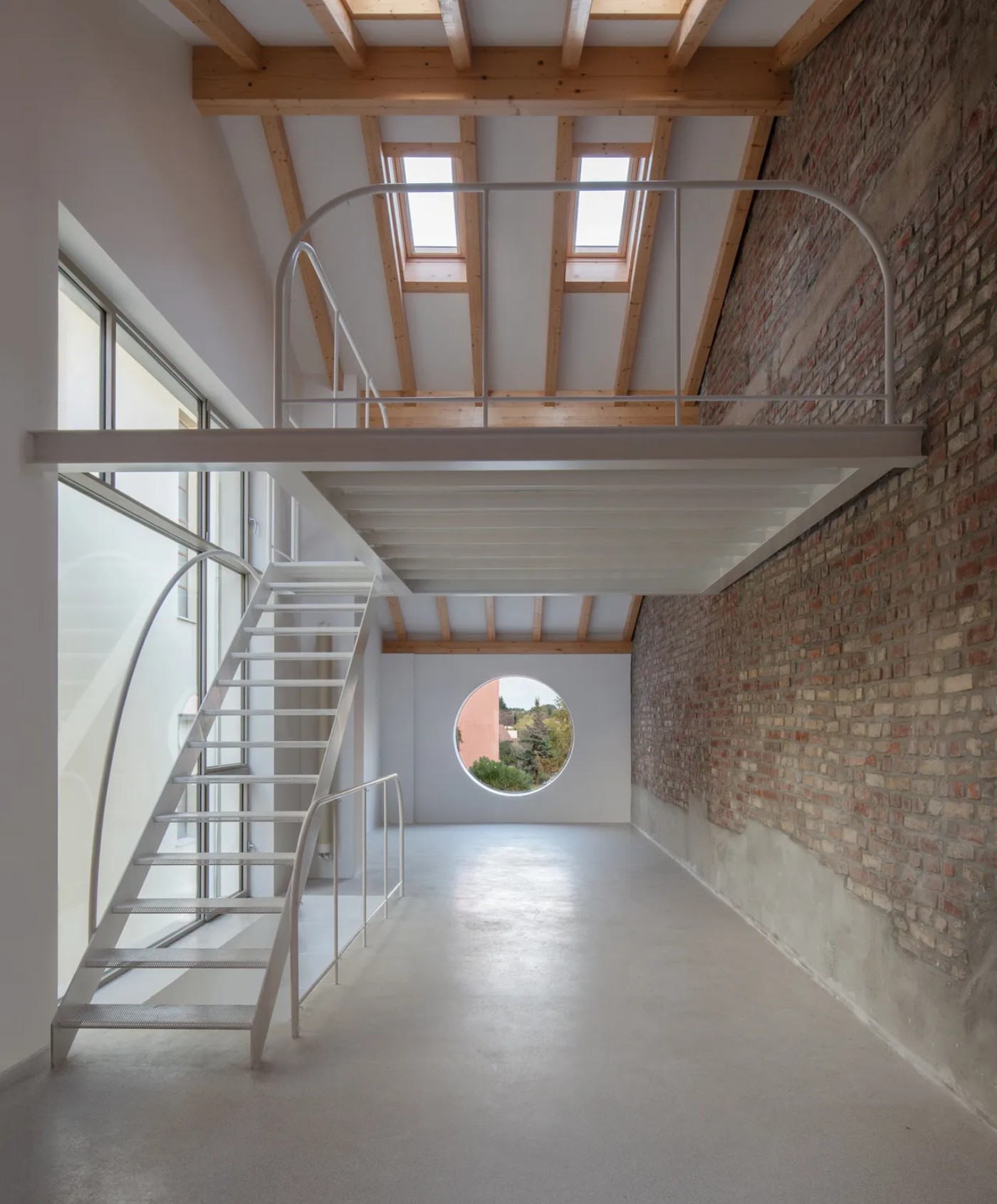 '009_Blue Bird Kitchen' by Studio Tropicana — A double-height interior volume demonstrates post-and-beam construction with exposed timber rafters and regularly spaced skylights flooding the concrete...