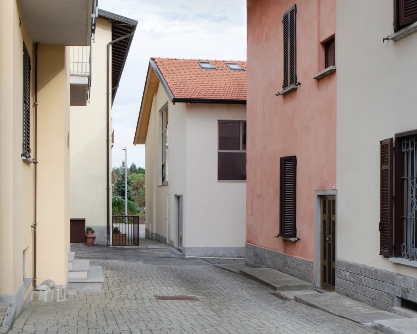 '009_Blue Bird Kitchen' by Studio Tropicana — A narrow courtyard passage connecting residential structures in Varese reveals the architectural language of Studio Tropicana's intervention.