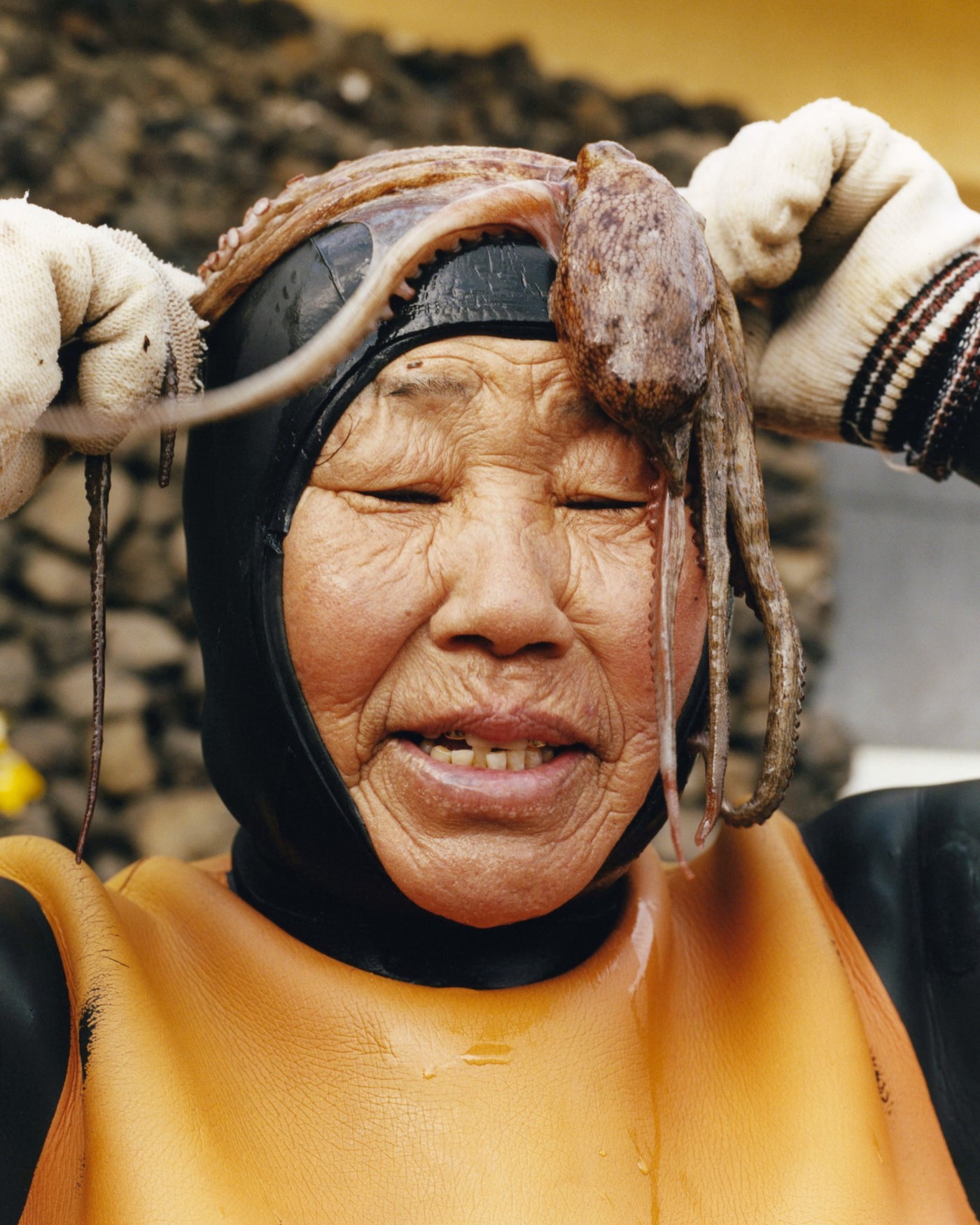 'The Last Mermaid' by Peter Ash Lee — Peter Ash Lee captures a Haenyo diver mid-preparation, her weathered face marked by deep creases and sun-darkened skin.