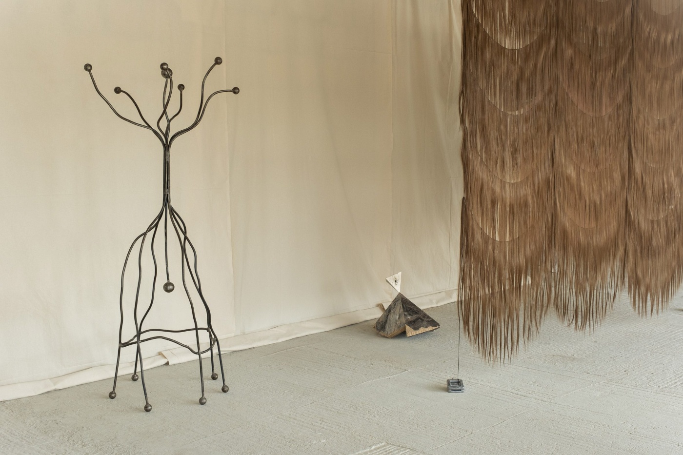 Forma - Nomad Gallery in Berlin by Forma Gallery — A gallery installation featuring two distinct sculptural works arranged across a light terrazzo floor.