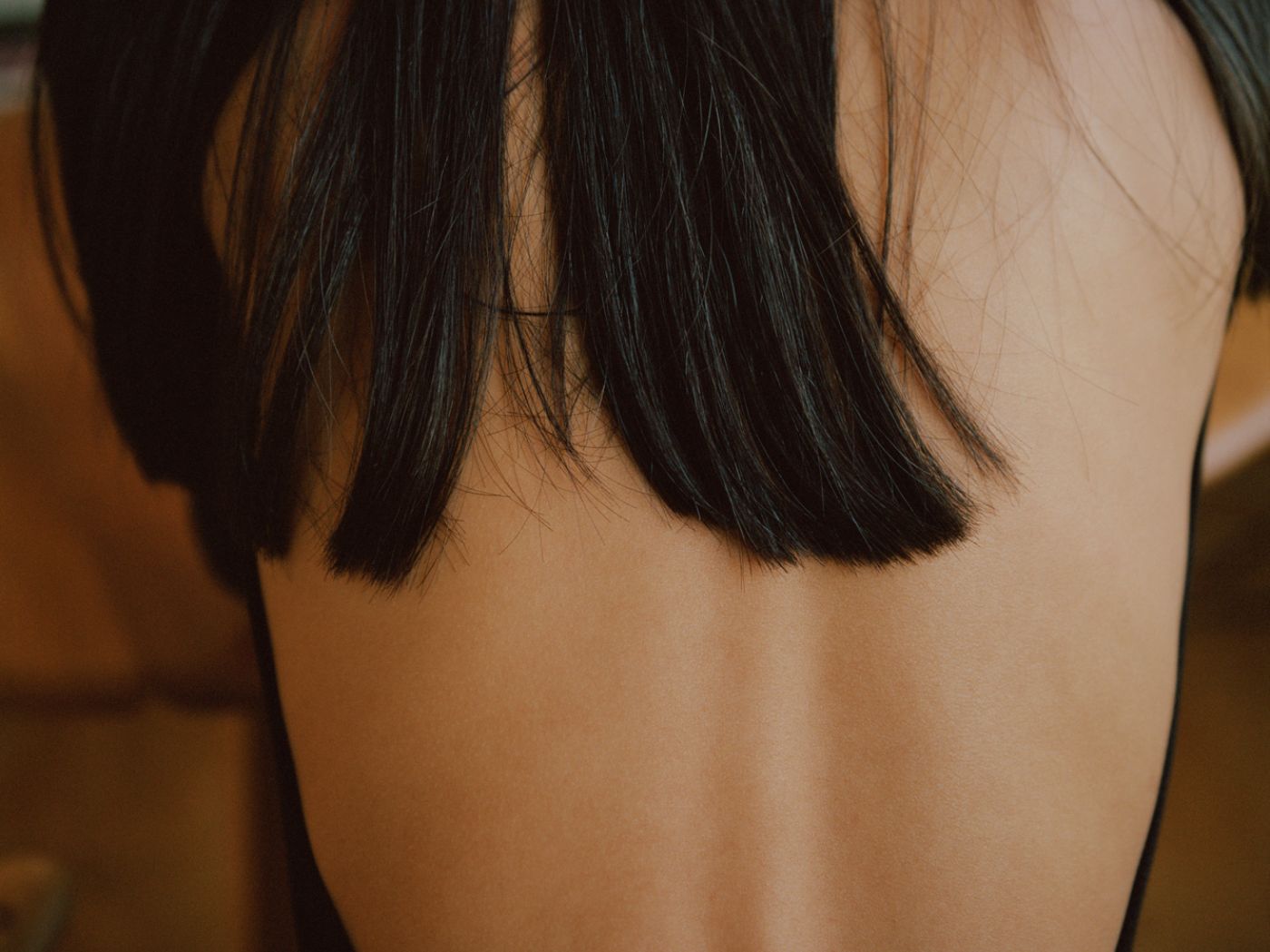 Visitors+ by Piczo — Close-up portrait photograph isolating the upper shoulders and lower face of a subject with dark hair.