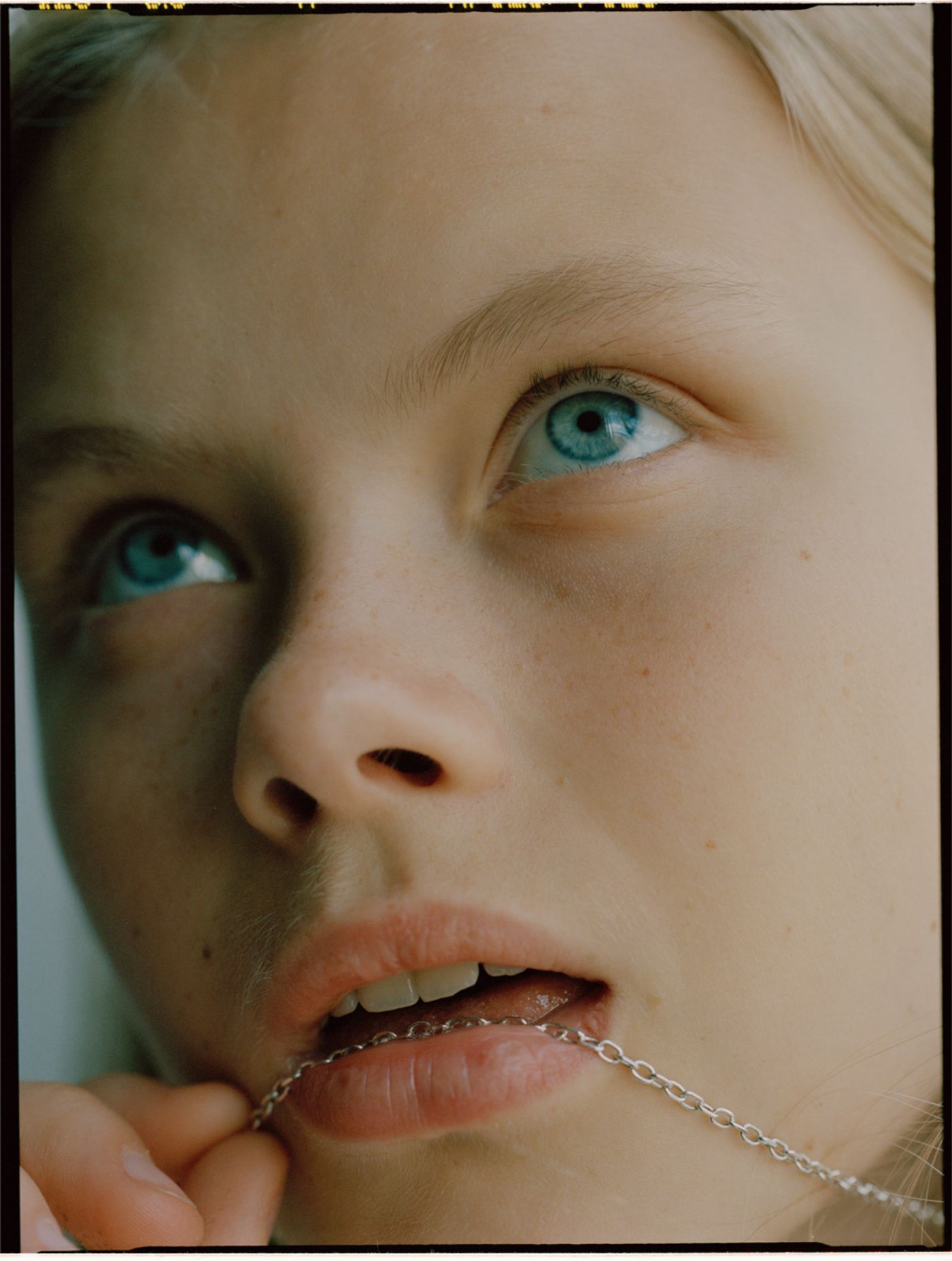 Visitors+ by Piczo — Close-up portrait shot with asymmetrical lighting creating pronounced shadow across the left side of the face.