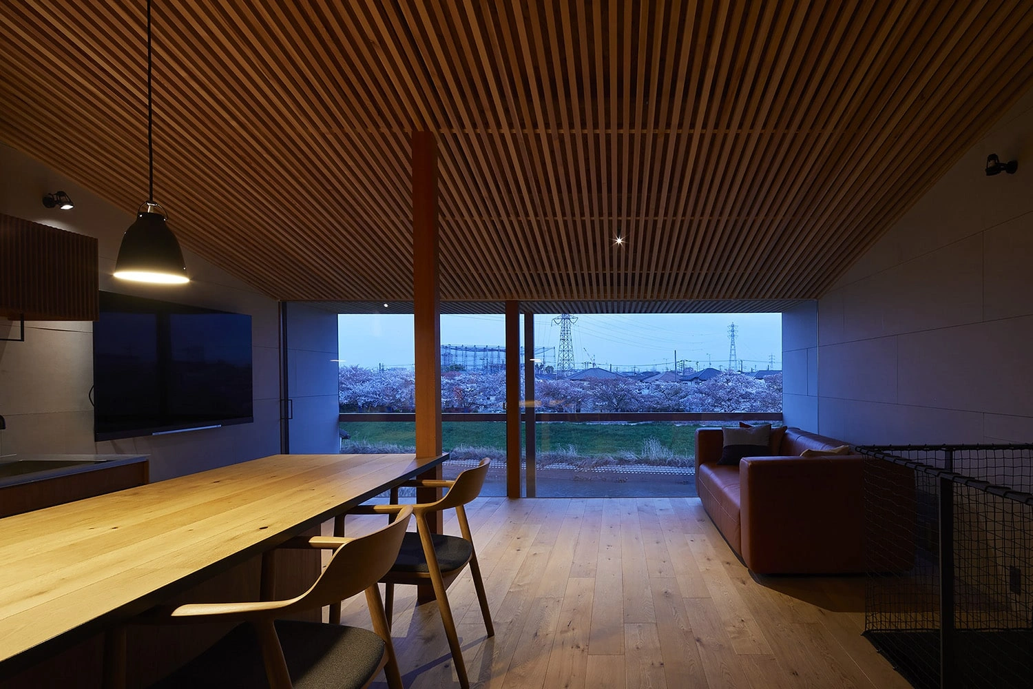 House in Gamo by Suppose Design Studio — The interior perspective reveals the spatial strategy underpinning House in Gamo: a single expansive volume unified by continuous timber flooring and a...