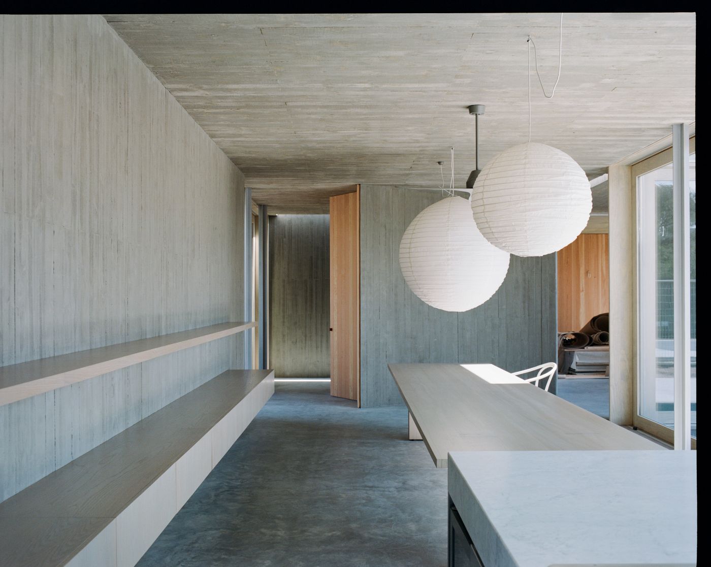 Mori House by Aires Mateus + MAArchitects — A corridor passage defined by whitewashed vertical timber wall paneling and a flush timber ceiling aligned with the cladding.