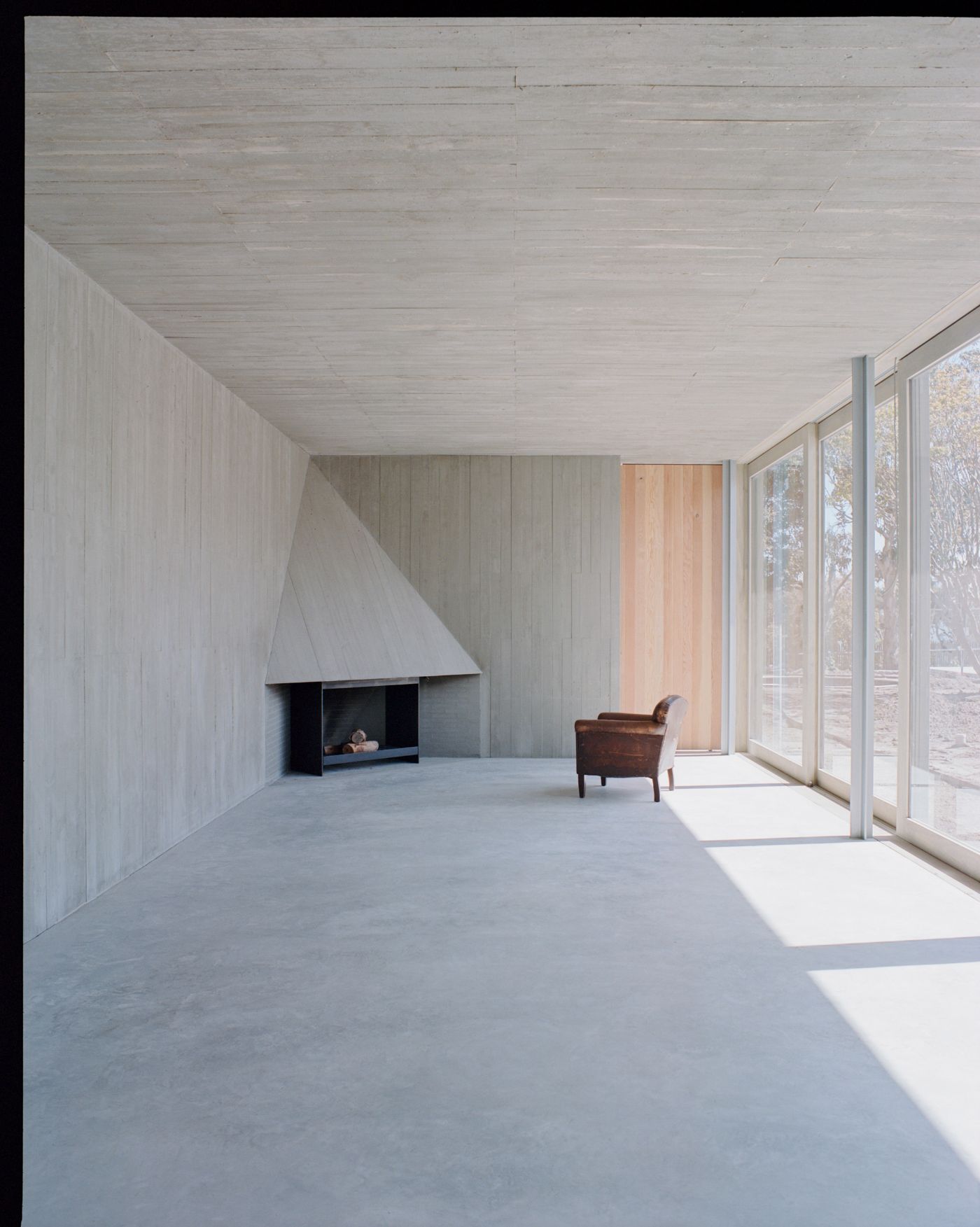 Mori House by Aires Mateus + MAArchitects — A minimalist interior bathed in rectangular light patches from the continuous glazed wall system.