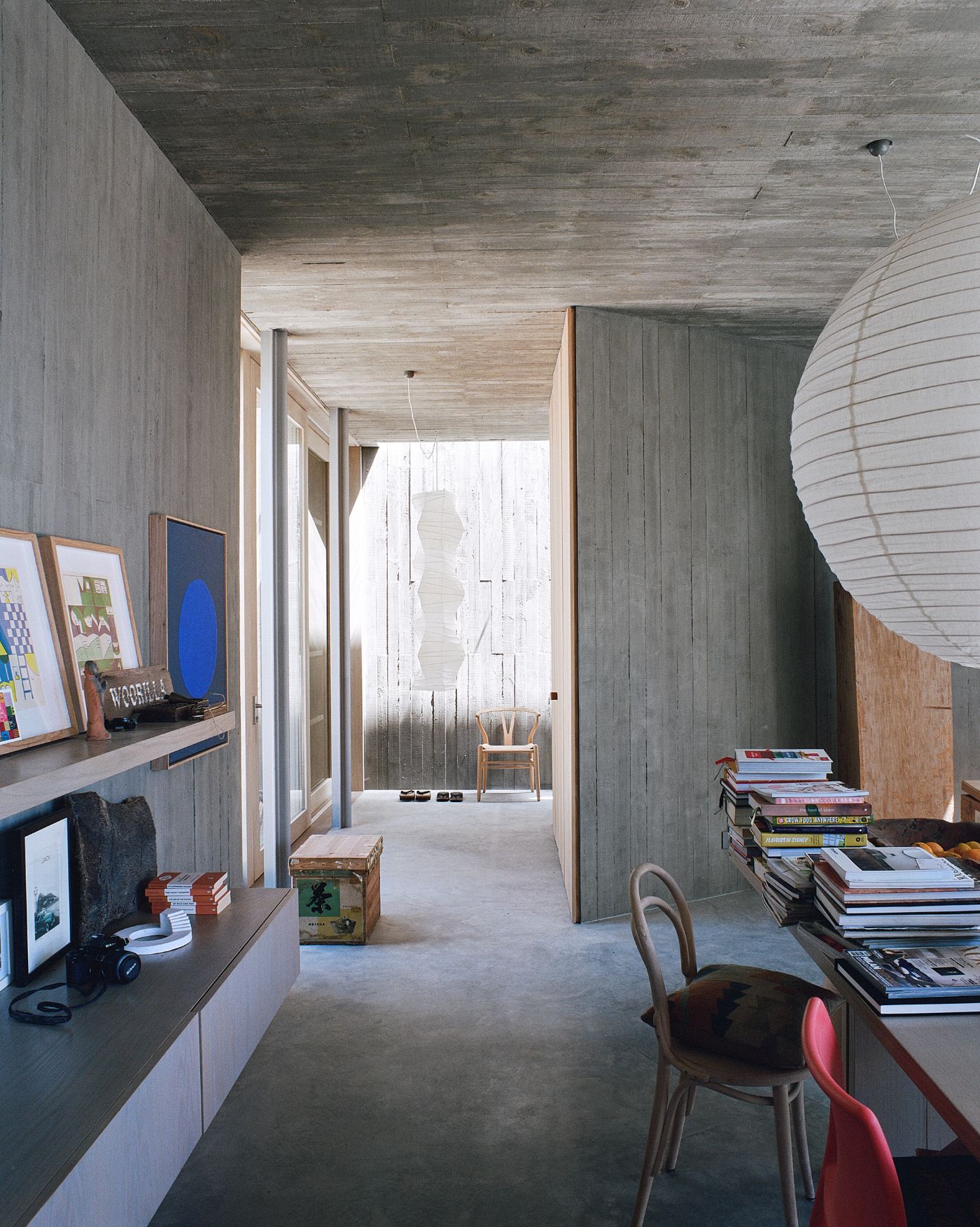 Mori House by Aires Mateus + MAArchitects — A corridor passage unified by flush timber ceiling boards and whitewashed vertical wall paneling, interrupted by a monolithic concrete structural wall.