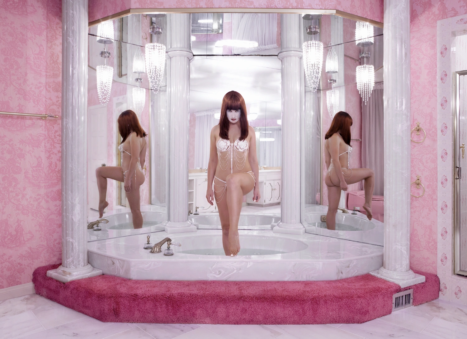 What to do with a Million Years by Juno Calypso — A figure stands in a circular marble bathtub at the center of a mirrored bathroom chamber.