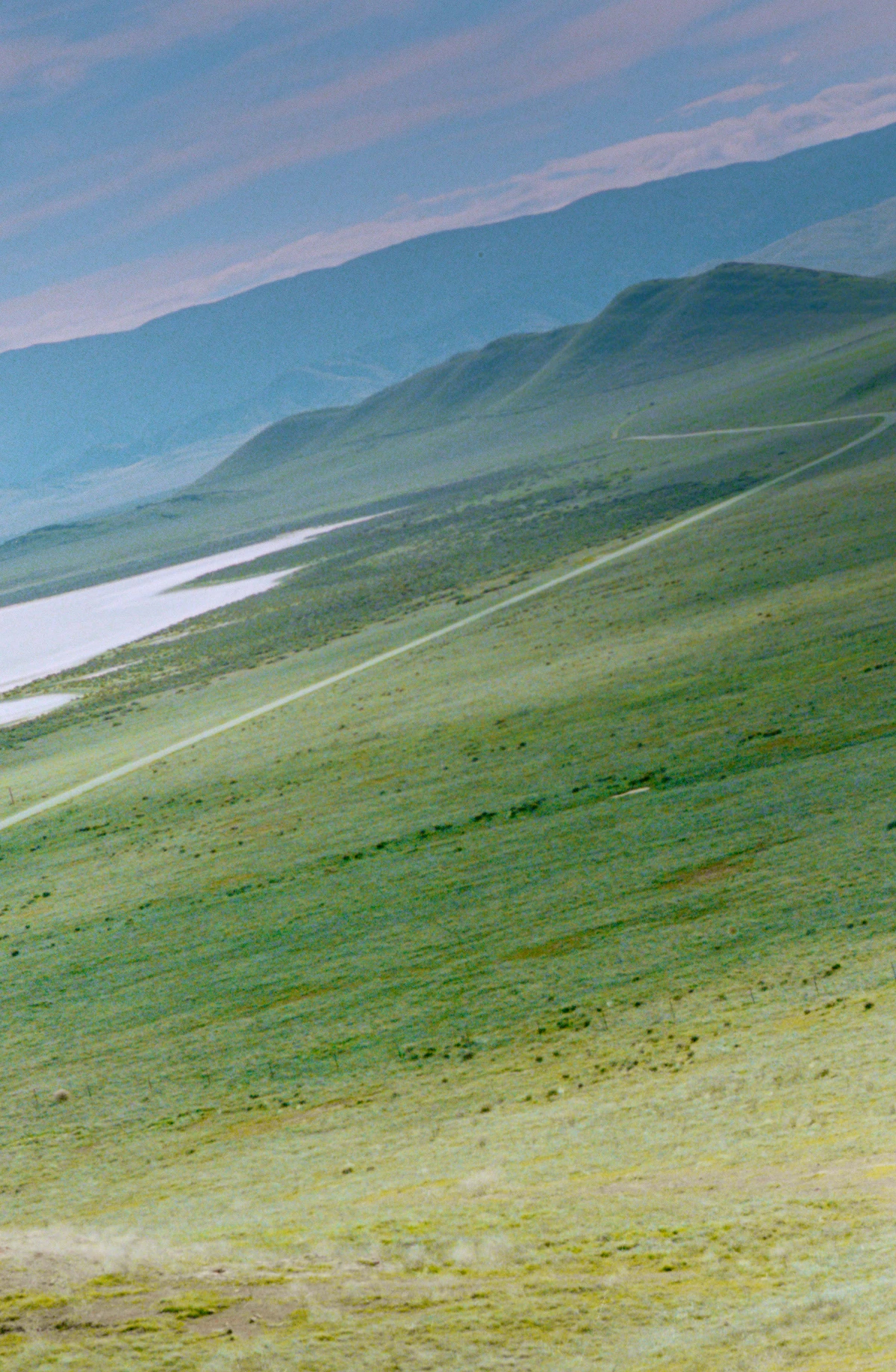 Selected works by Arianna Lago — Aerial landscape photograph capturing layered terrain descending toward a sinuous river or water body.