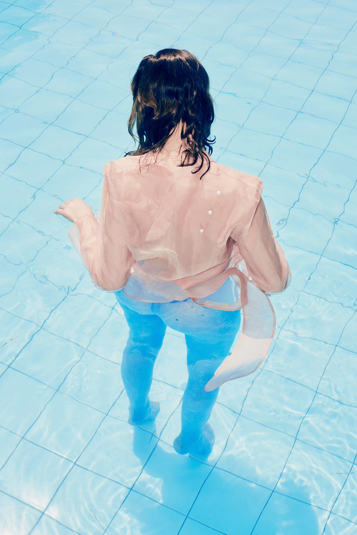 Selected works by Arianna Lago — Overhead photograph of a figure in shallow pool water, shot from directly above.