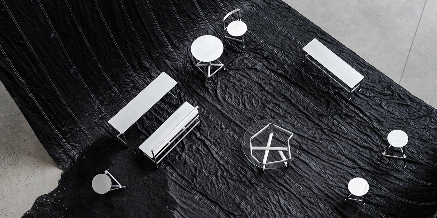MONOCHROME by Ximi Li — Overhead view of Ximi Li's aluminum furniture installation on a textured black surface.
