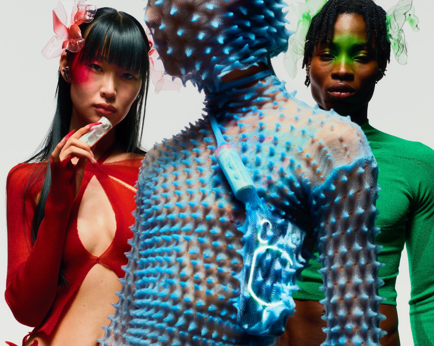 Nothing x Chet Lo — A three-figure composition staged against a white cyclorama featuring bold color blocking and textural contrasts.
