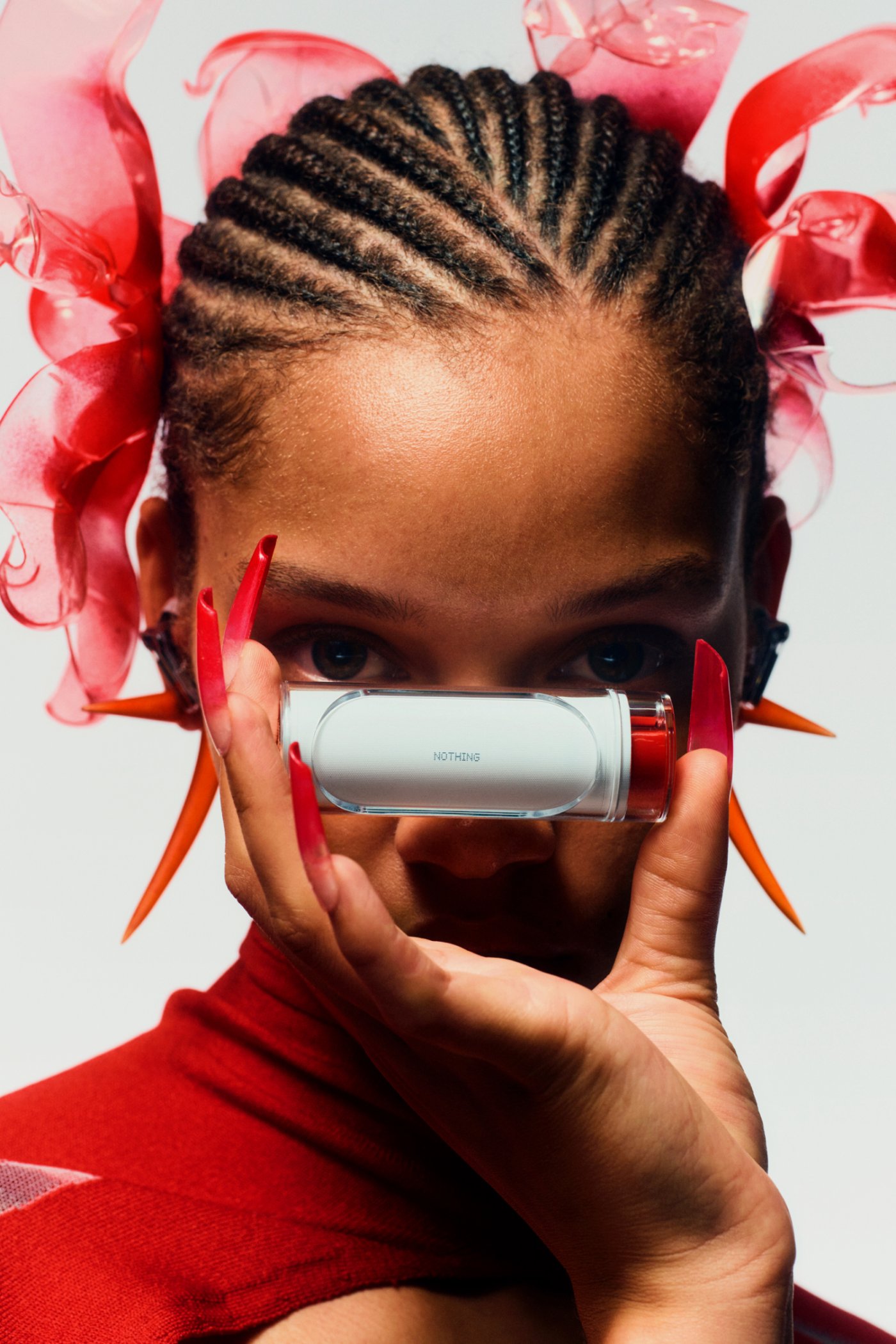 Nothing x Chet Lo — A close-up portrait presents the Nothing Ear (stick) as a cylindrical tech accessory held before the subject's face.