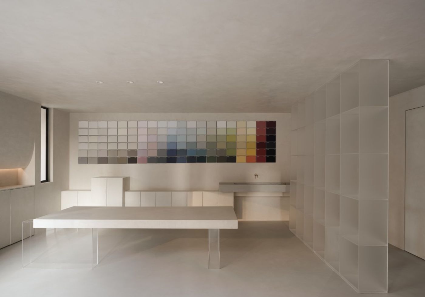 Novacolor Store by LICO Design — The Novacolor Store showroom demonstrates material contrast through a minimalist interior centered on a color sample grid wall.