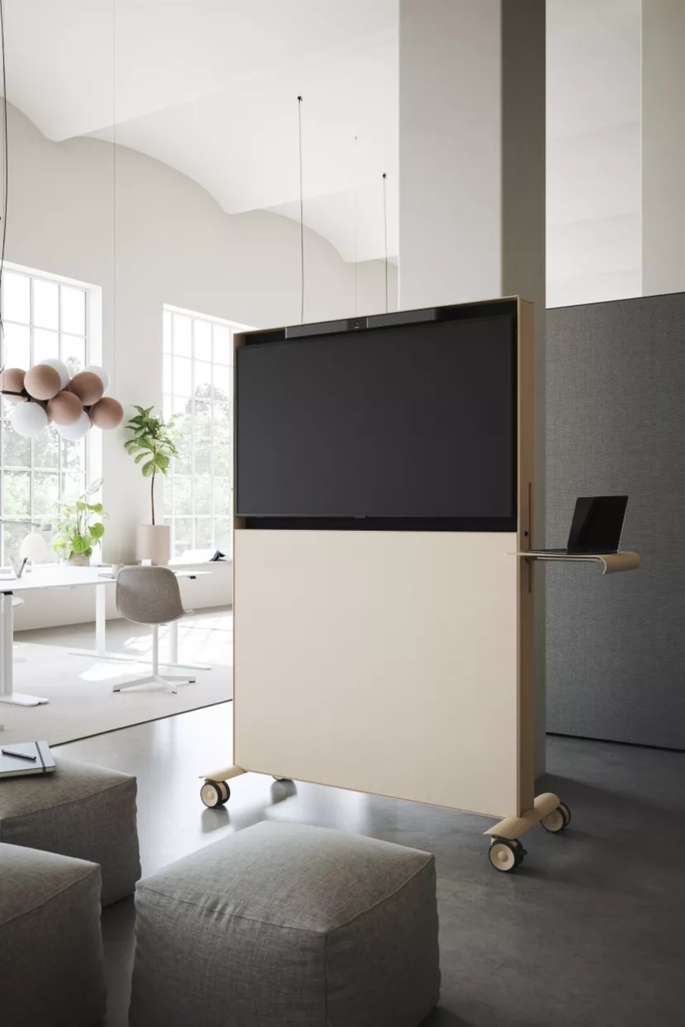 Abstracta Agile by Studio Stockholm by Studio Stockholm for Abstracta — Mobile partition screen on castors with dual-material construction: black display panel mounted above cream-colored acoustic fabric, suspended from timber...