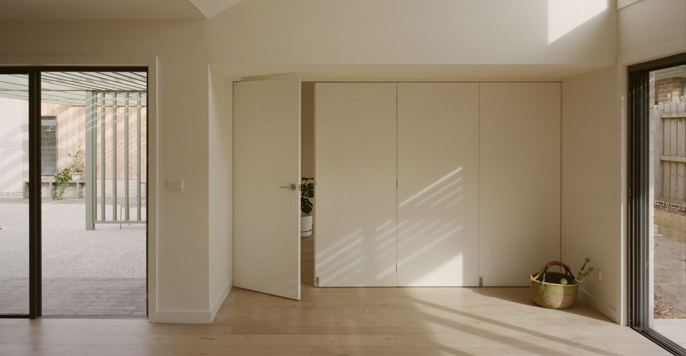 WPI Older Women’s Housing Project by Bright Studio by Studio Bright — Interior passage connecting outdoor courtyards through a domestic threshold.