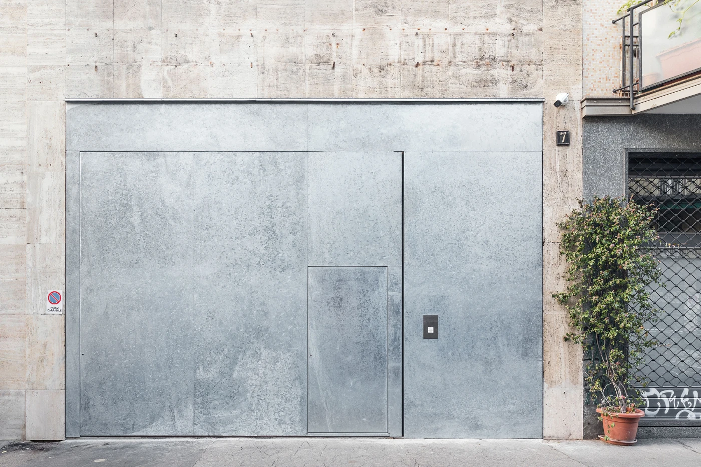 Spazio Maiocchi in Milan — A monolithic galvanized metal facade dominates the streetfront of Spazio Maiocchi, its weathered surface displaying uniform patination across two recessed...
