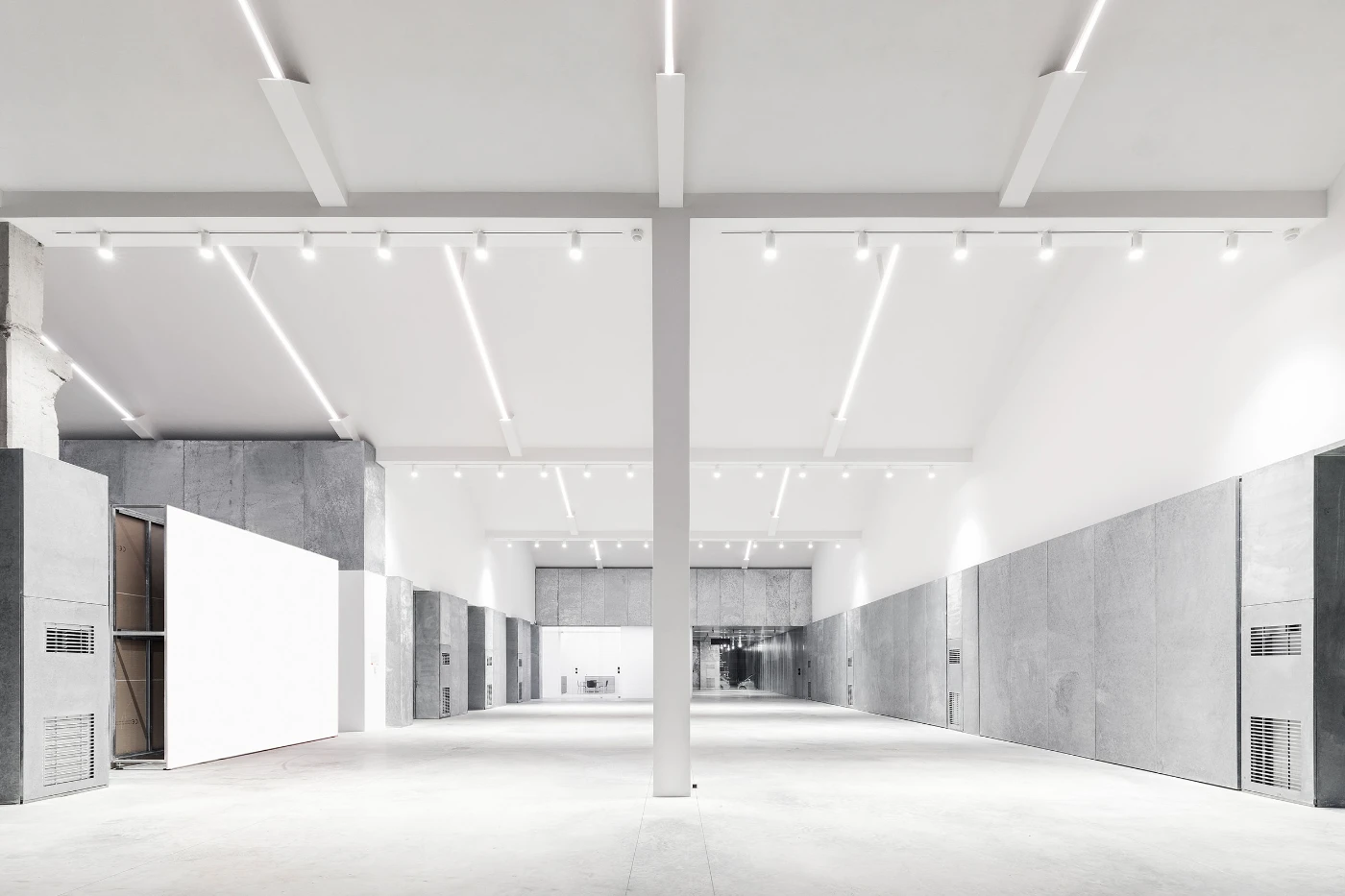 Spazio Maiocchi in Milan — A symmetrical corridor extends through Spazio Maiocchi's converted industrial space, bisected by a central concrete support column.