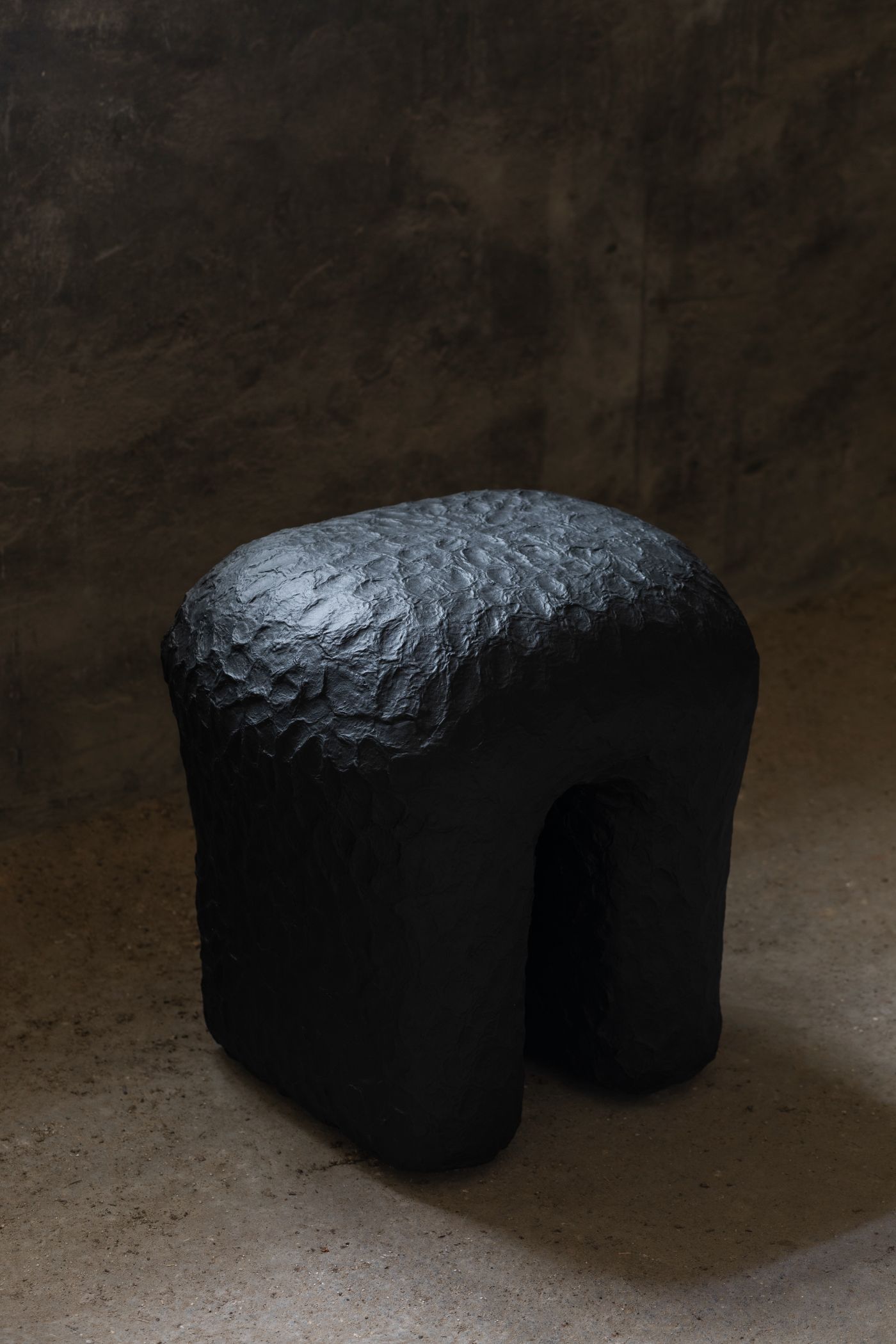 Limited collection by Victoria Yakusha — Hand-sculpted stool from Victoria Yakusha's 'Stepping on Ukrainian soil' collection, featuring a monolithic charcoal form with four tapered cylindrical legs...