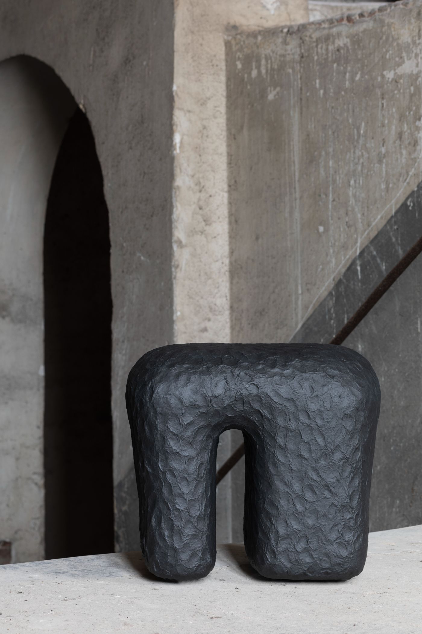 Limited collection by Victoria Yakusha — A hand-sculpted stool from Victoria Yakusha's limited collection, positioned on pale concrete flooring.