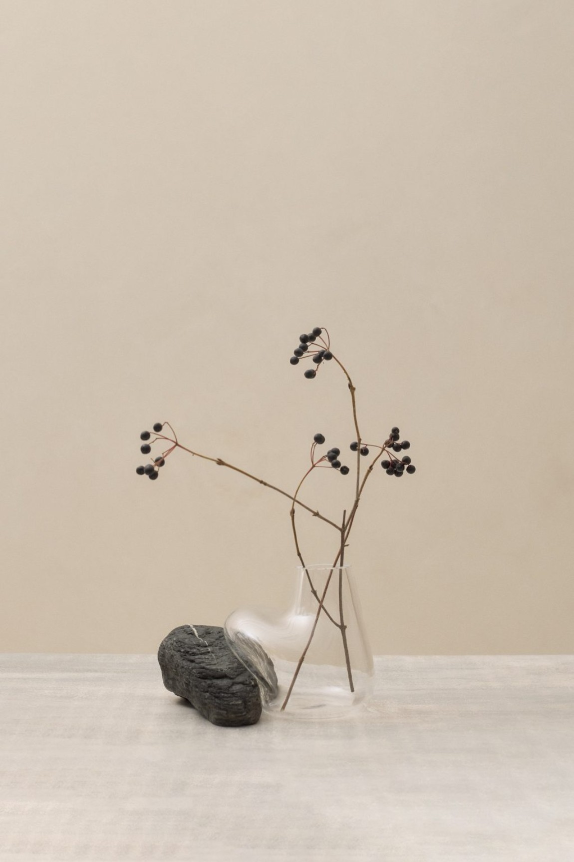 Vase Sculptures by Lætitia Jacquetton — Mouth-blown glass vessel with asymmetric bulbous form cradles a weathered stone collected from natural sources.
