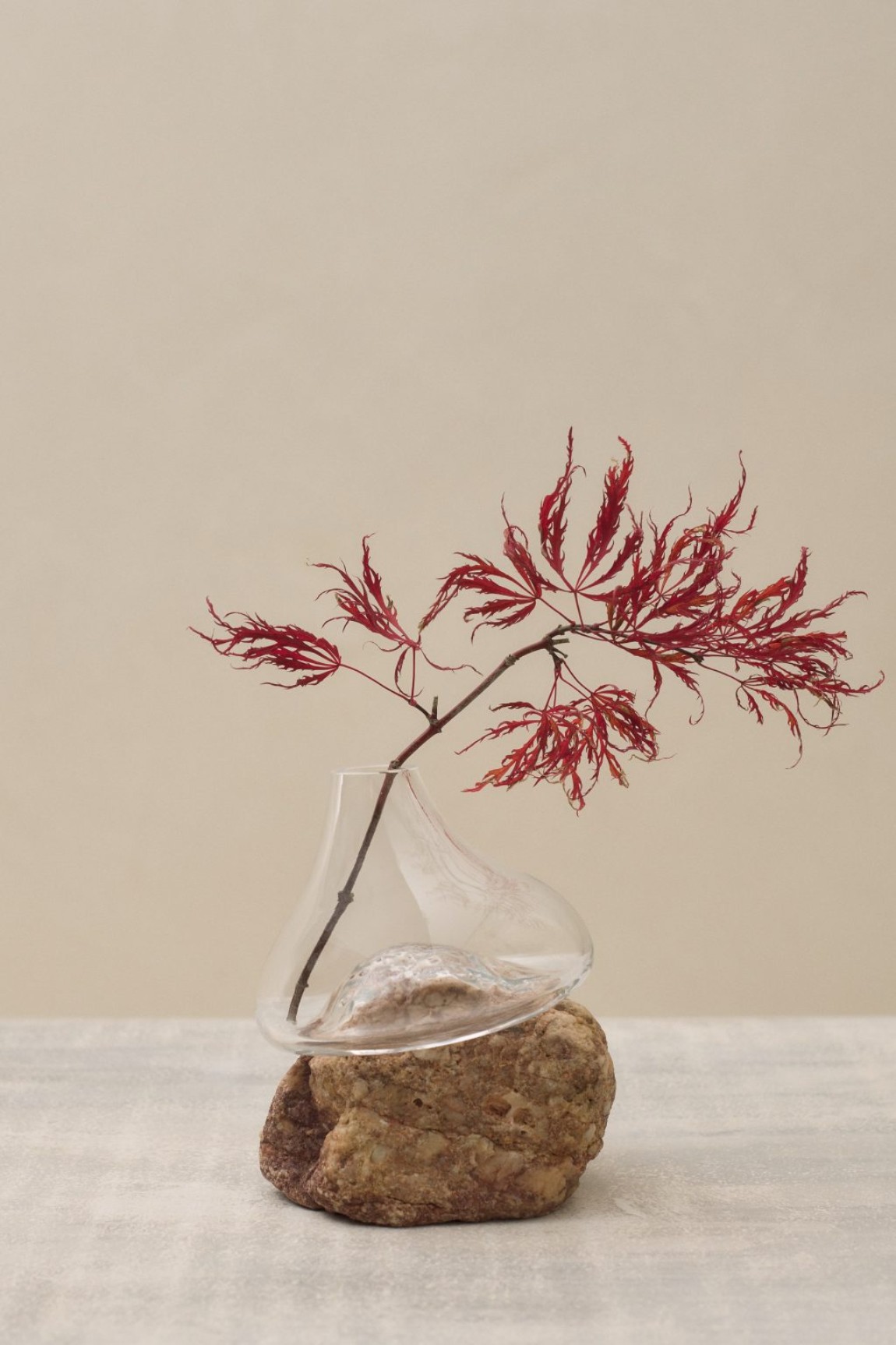 Vase Sculptures by Lætitia Jacquetton — A mouth-blown glass vessel with irregular bulbous form envelops a weathered stone base collected from natural landscapes.