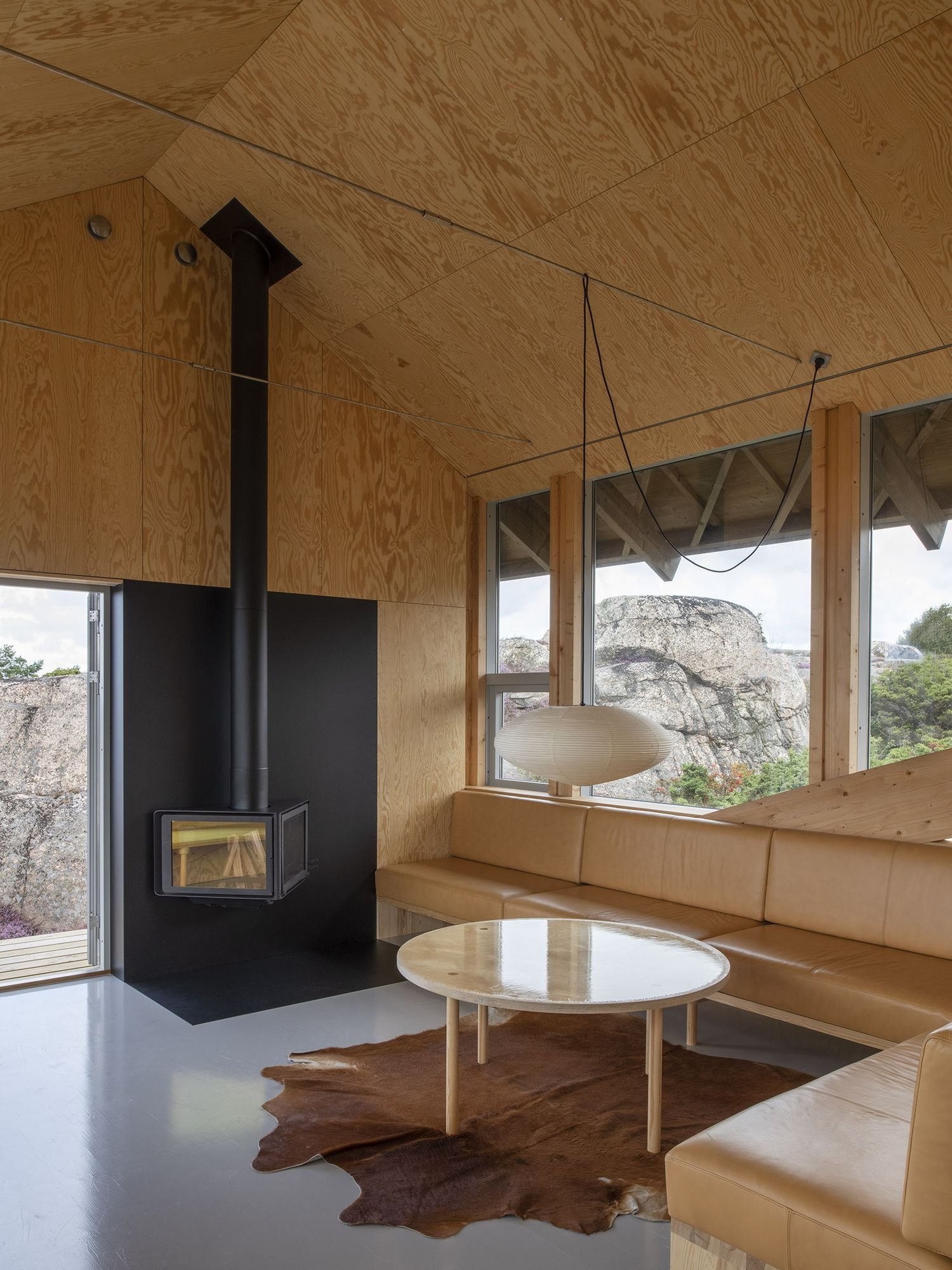 House Hamburgö by Manthey Kula — Interior view of the timber-arch bridging structure, where plywood-clad walls and ceiling create a unified envelope.