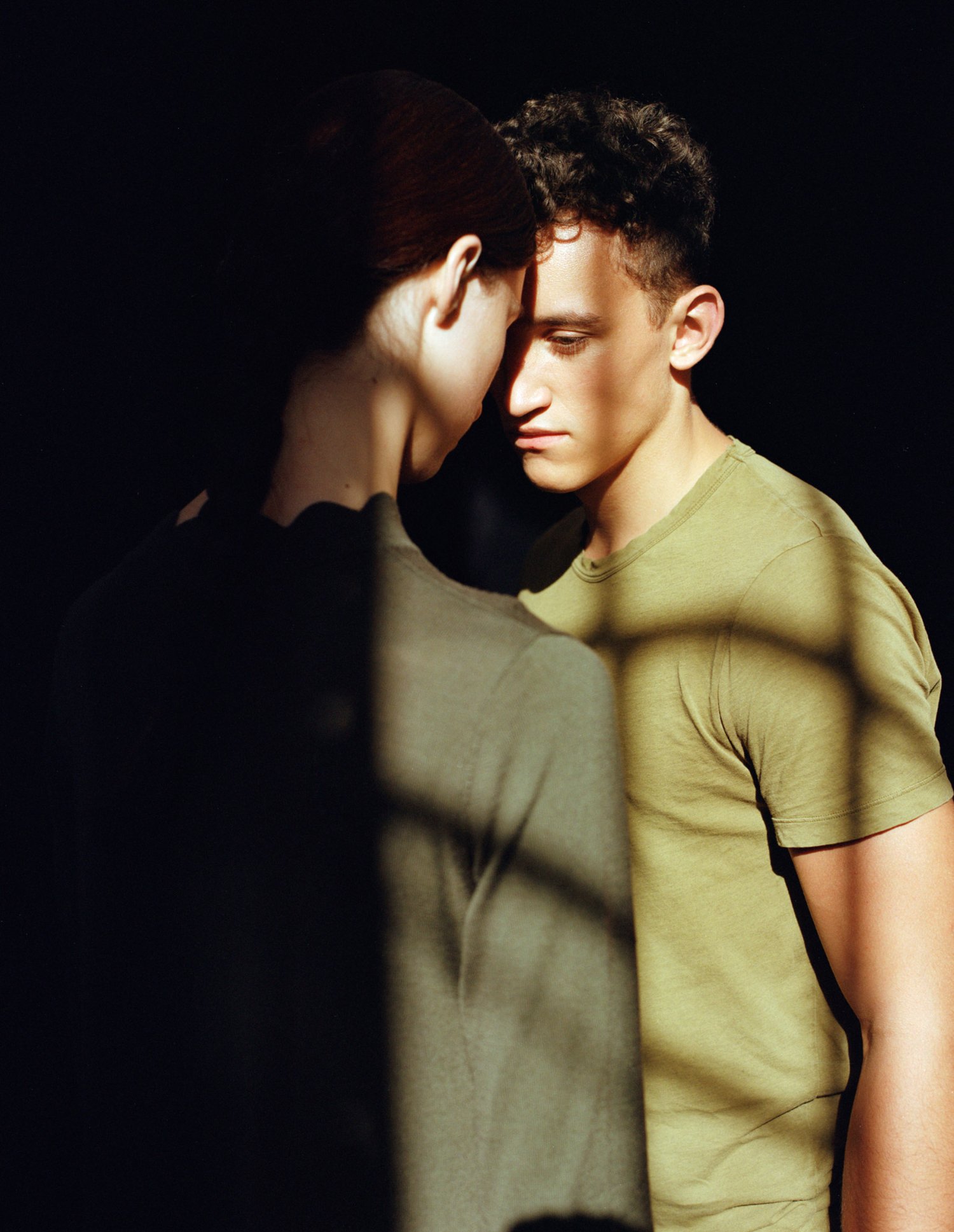 Thisispaper Bags & Backpacks Collection by Thisispaper Studio — Two figures positioned against a black backdrop, illuminated by natural light.