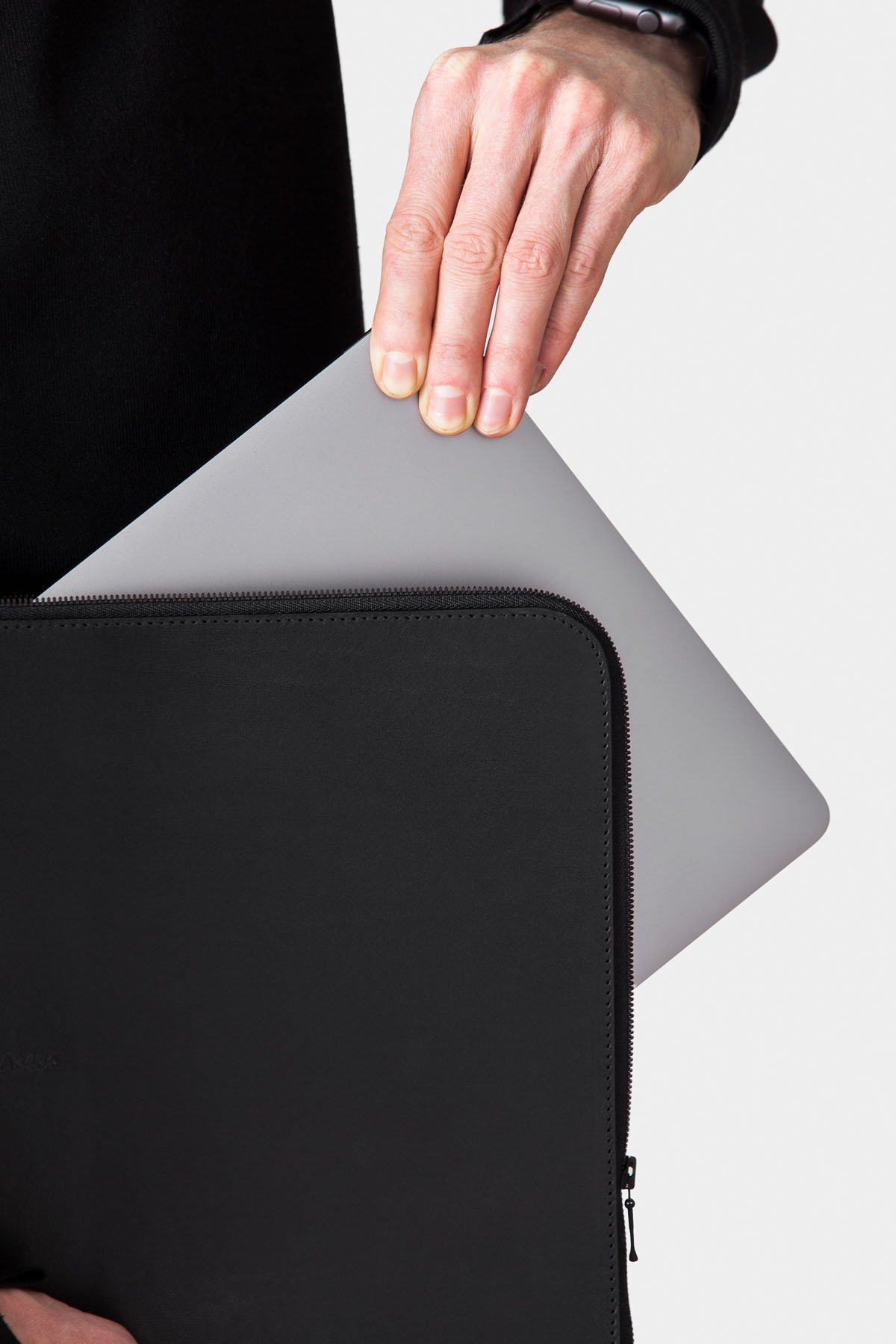 A345+ by Thisispaper Studio — A345+ leather case is captured mid-extraction from its protective black neoprene sleeve, revealing the nested rectangular compartments that define the...