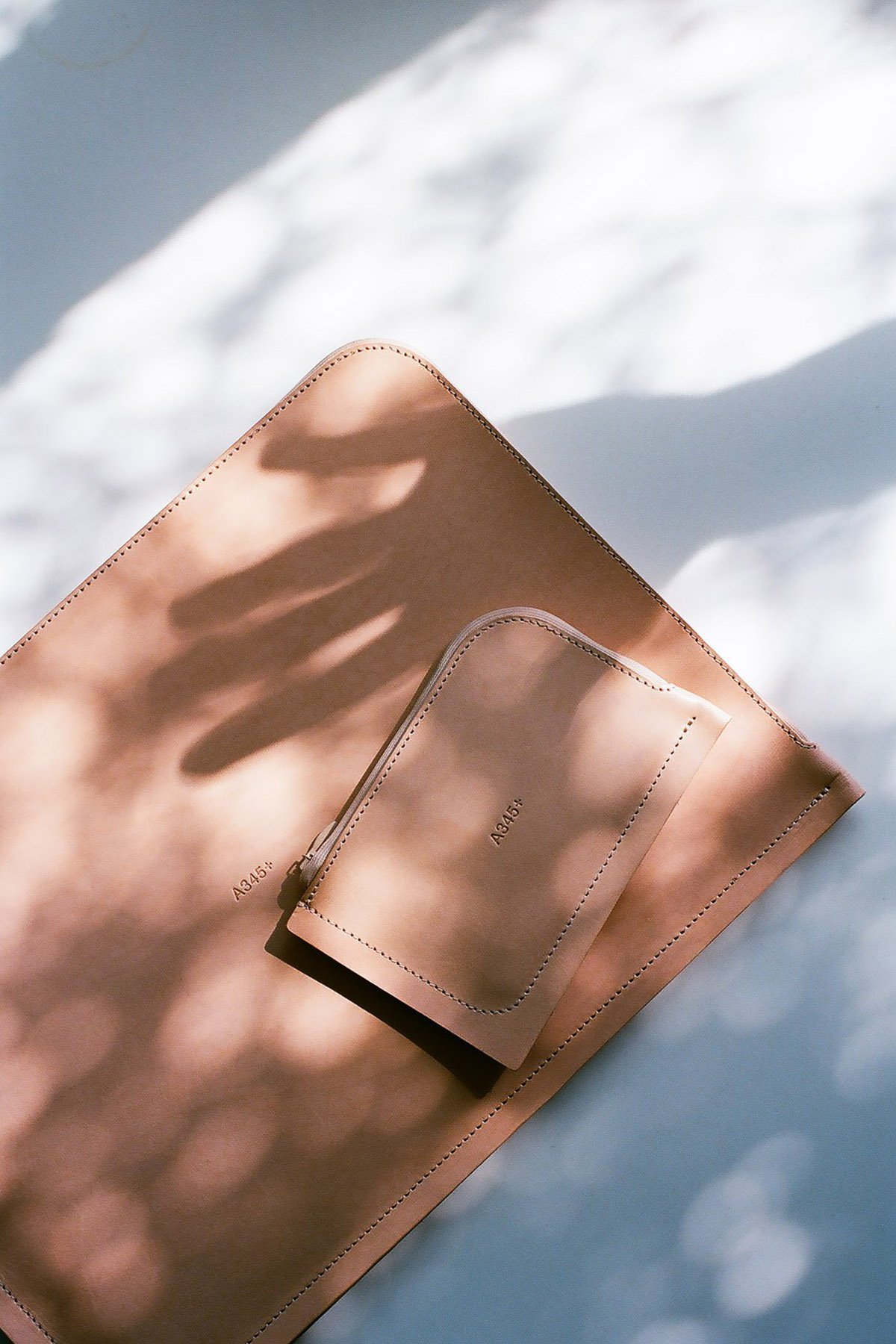 A345+ by Thisispaper Studio — A345+ leather accessories photographed in overhead composition against soft natural light.
