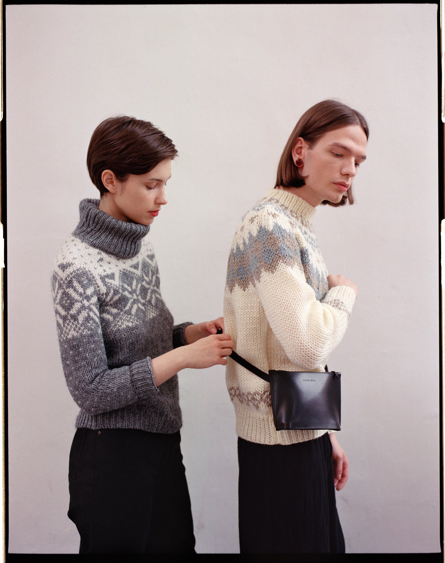 Yenisei by Thisispaper Studio — Two figures wearing jacquard-patterned wool turtleneck sweaters demonstrate the proportions and functionality of Yenisei's leather accessories.
