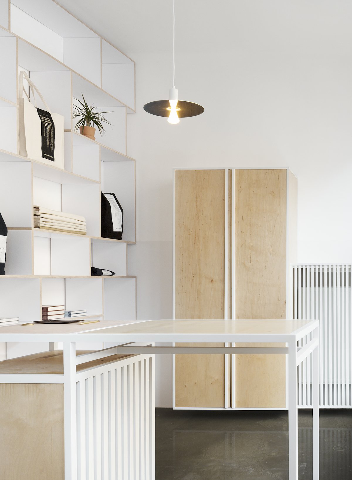 Thisispaper Warsaw Flagship Store by Thisispaper Studio — The Thisispaper Warsaw Flagship Store interior features a floor-to-ceiling modular plywood shelving system with white-painted frame and horizontal timber...