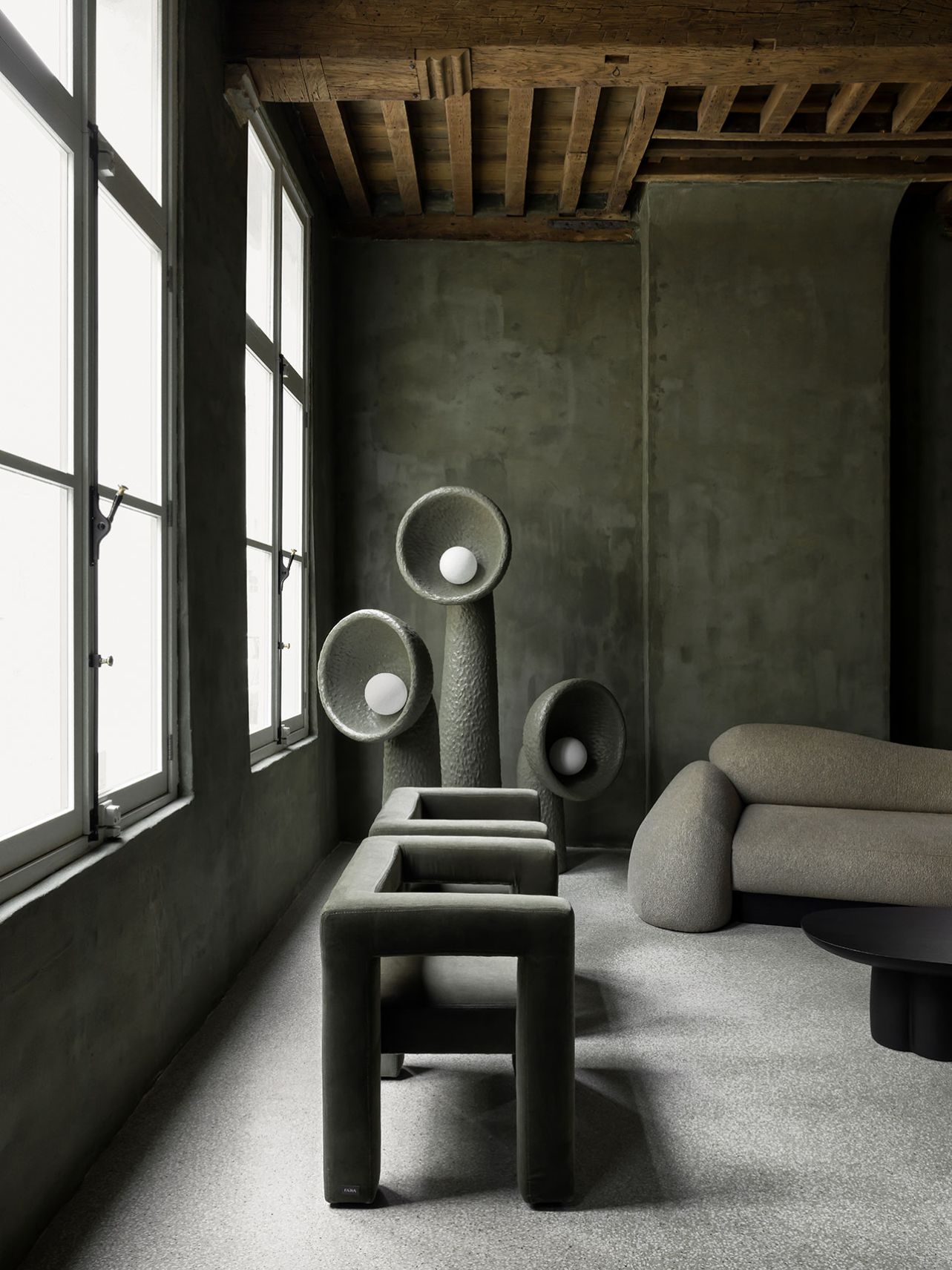 Faina Gallery by Yakusha Studio — A narrow gallery passage lined with hand-rendered charcoal-grey walls bearing visible trowel marks and organic surface variation.