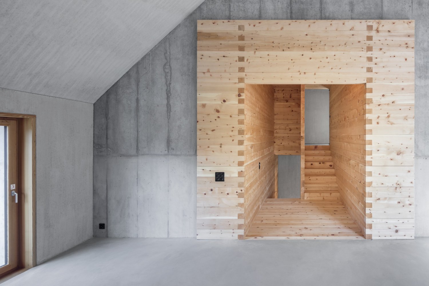 The Trin Cabin By Schneller Caminada Architects — Interior view of the Trin Cabin revealing the volumetric timber-frame construction system.