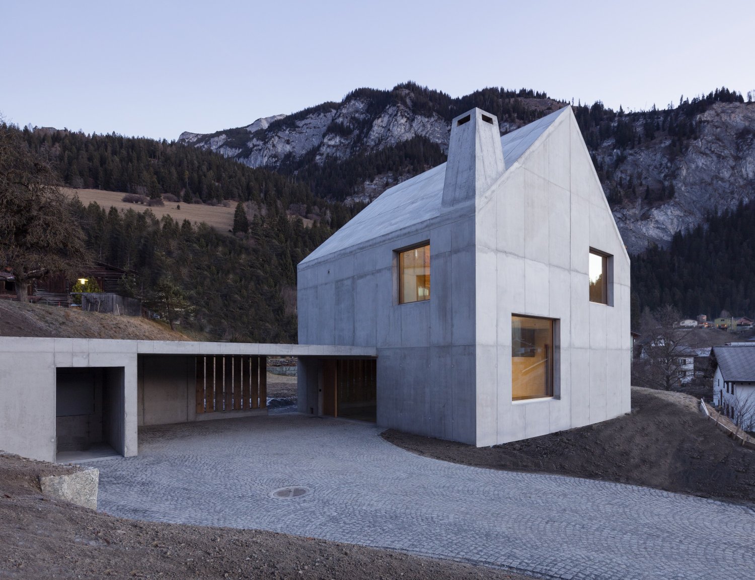 The Trin Cabin By Schneller Caminada Architects — A three-story single-family dwelling in Trin, Switzerland, clad in light concrete with local pigmentation.
