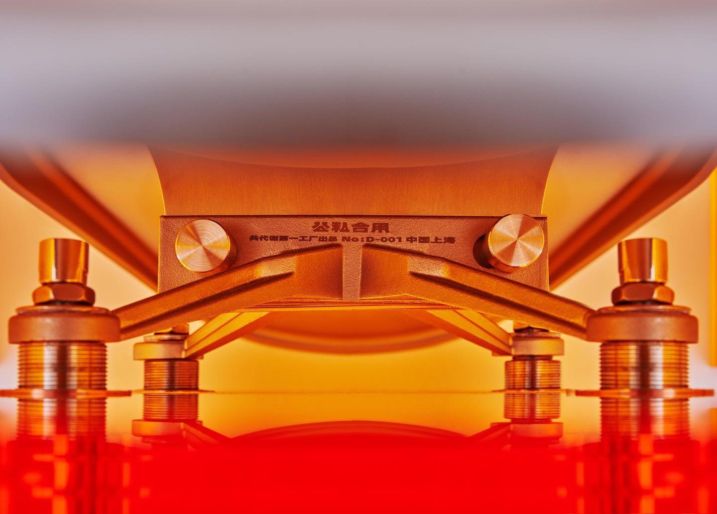 Mixed Public-Private Boundary collection by Cometabolism Studio — Symmetrical front-view composition of a translucent orange structural frame mounted on a stepped concrete base.