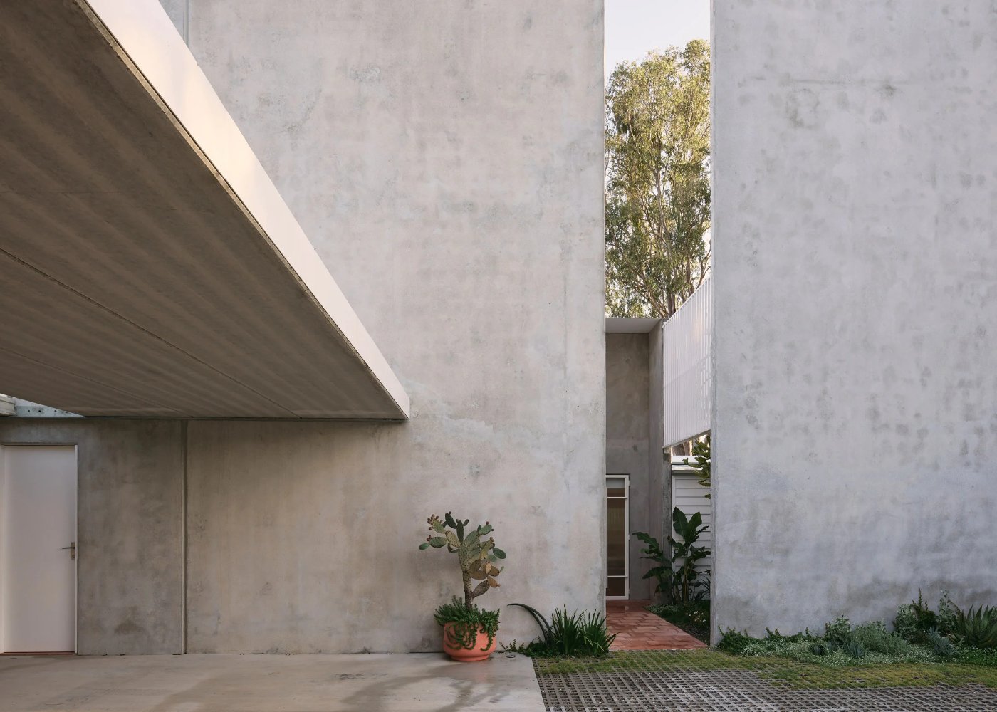 Chelmer River House by Furminger by Christopher Furminger — A monolithic concrete courtyard void frames the passage between two tilt-up panel walls rising to full height.