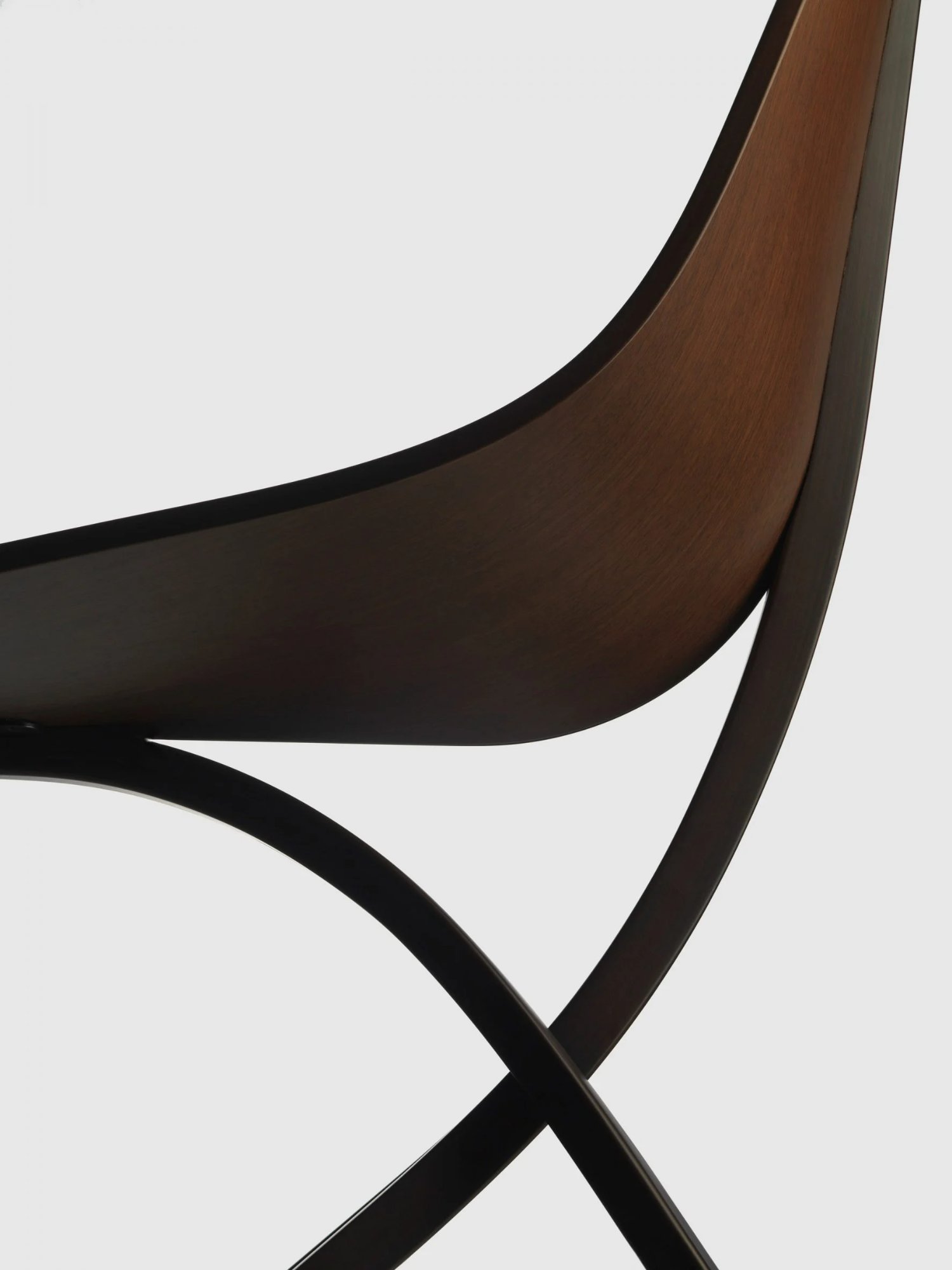 Edaha chair by GamFratesi for Koyori — Close-up detail of the Edaha chair revealing the joinery where curved veneer seat meets crossed wooden frame.