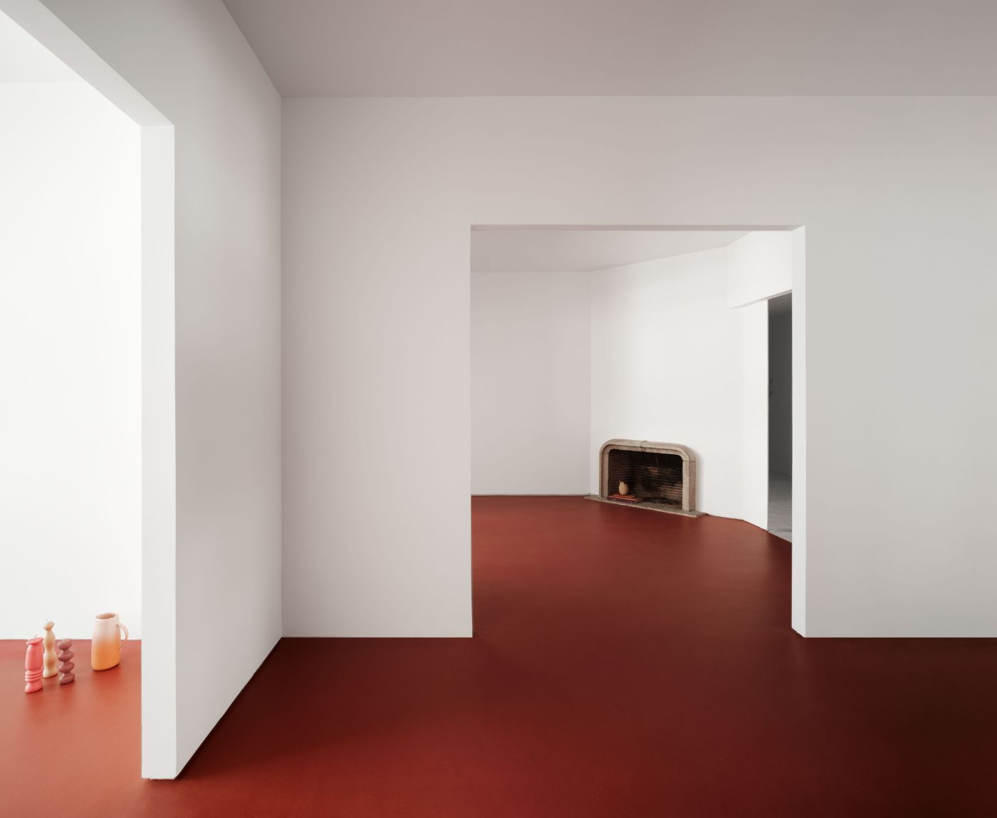 Lara House by HANGHAR — A rectilinear interior space defined by contrasting material planes: terracotta linoleum flooring and lower wall treatment confronts bright white plaster...