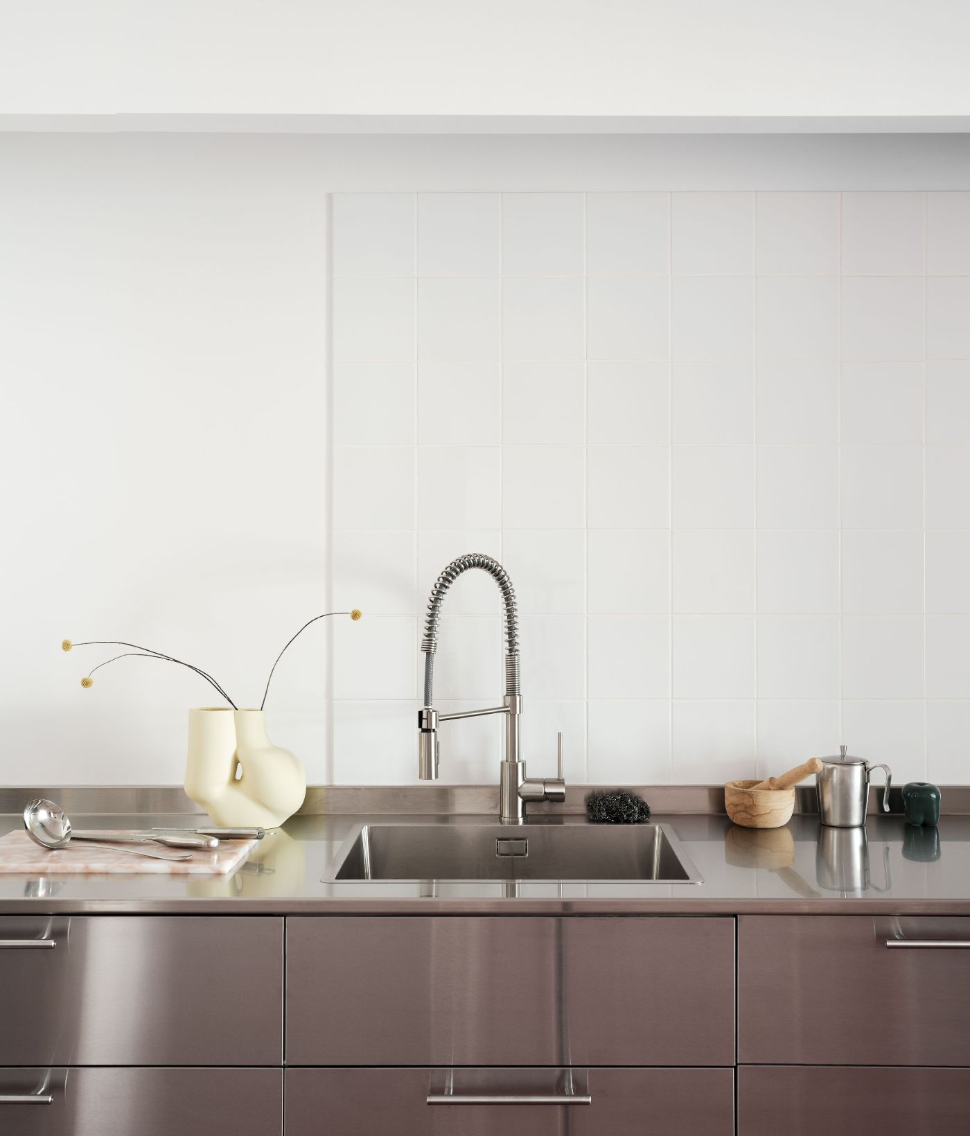 Lara House by HANGHAR — The kitchen counter presents a studied composition of functional minimalism.