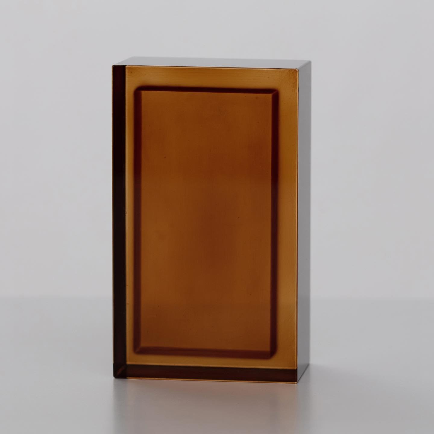 Block Series by Rahee Yoon — A translucent acrylic block sculpture from Rahee Yoon's Block series, rendered in amber and deep brown tones.