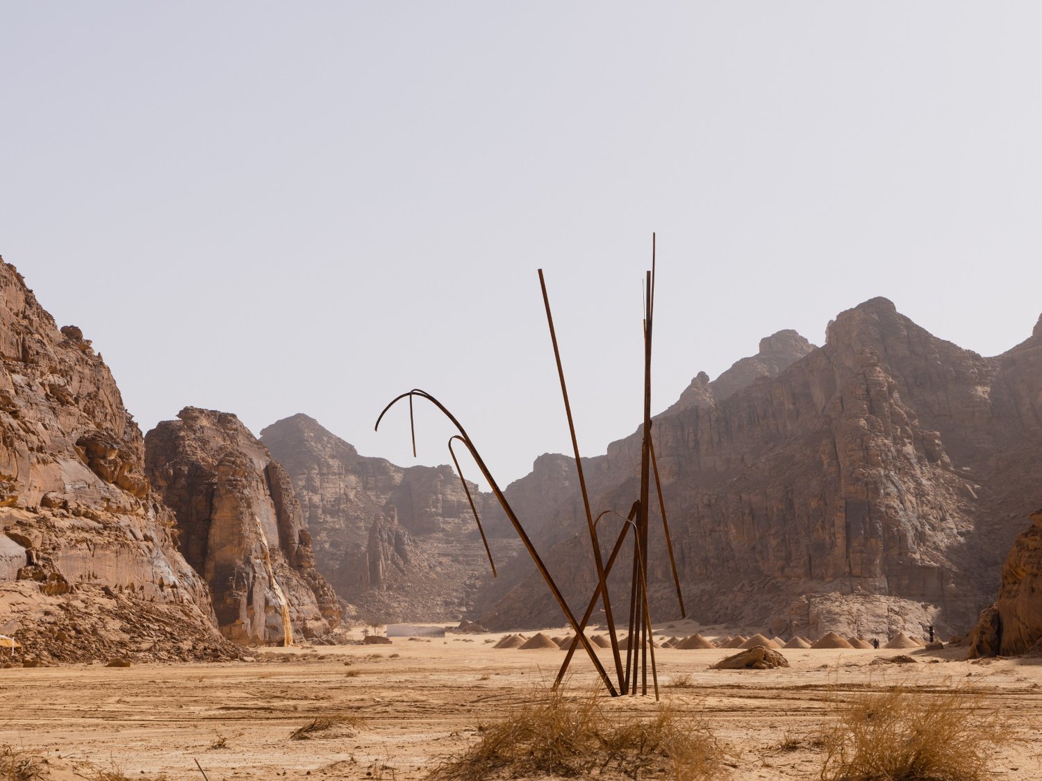 Desert X AlUla 2022 Group Exhibition — A welded-steel sculpture comprises curved and vertical elements rising from the desert floor, their rusted patina contrasting against the monumental...