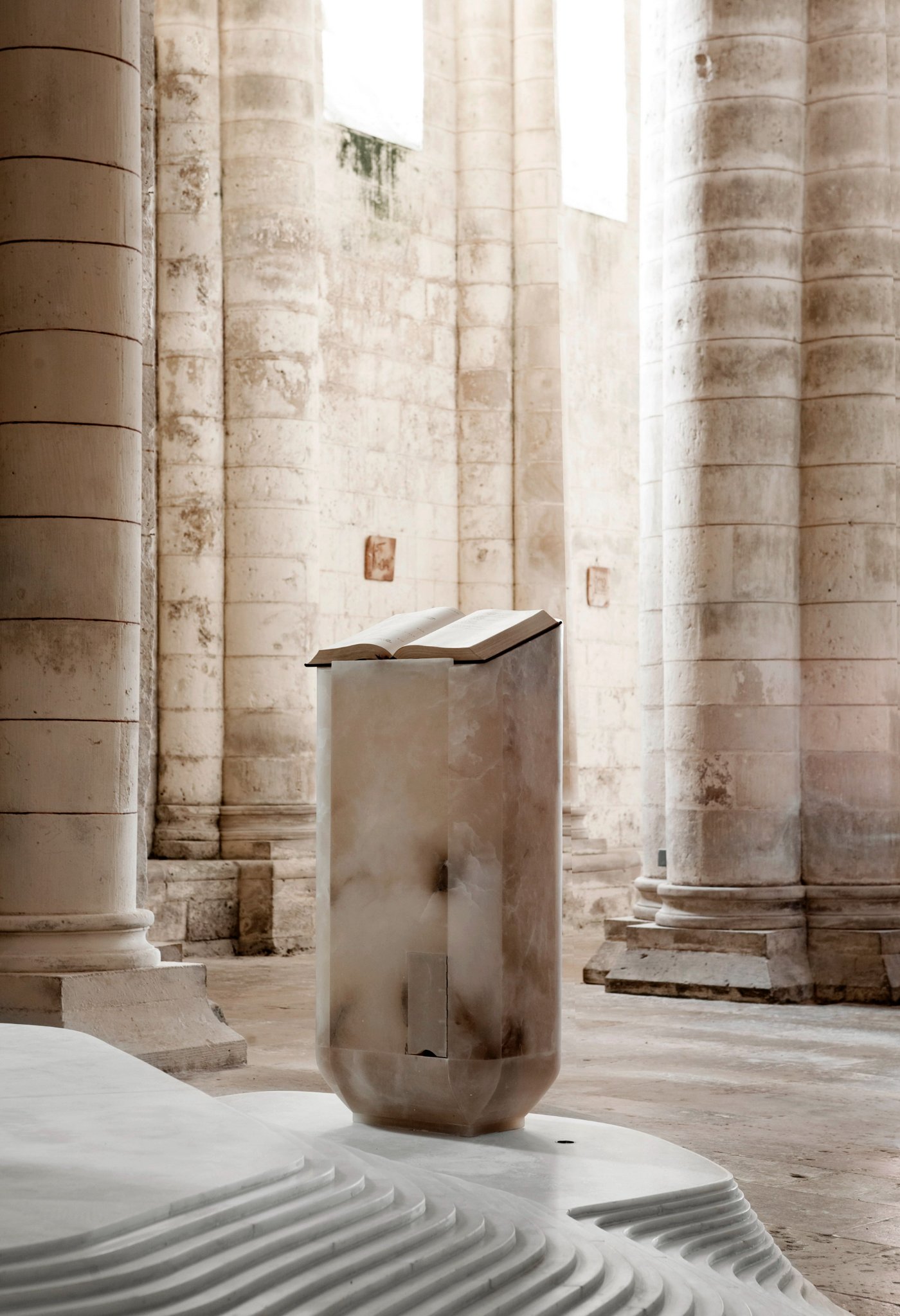 St Hilaire Church in Melle by Mathieu Lehanneur — A monolithic alabaster volume dominates the nave, its cylindrical form hollowed at the base and topped with an open book-like ledge.