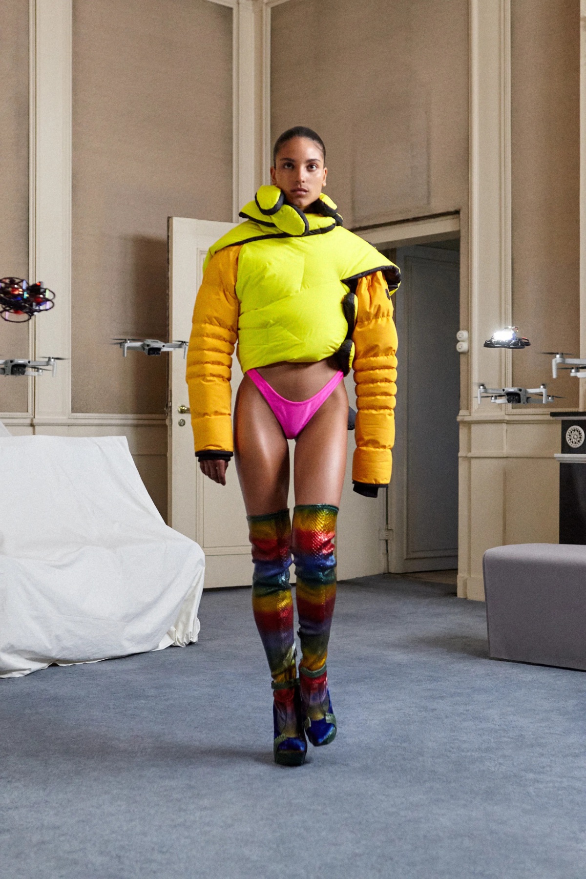 SSAW22 by Duran Lantink — A model wears a boldly color-blocked ensemble by Duran Lantink in a minimalist interior setting.