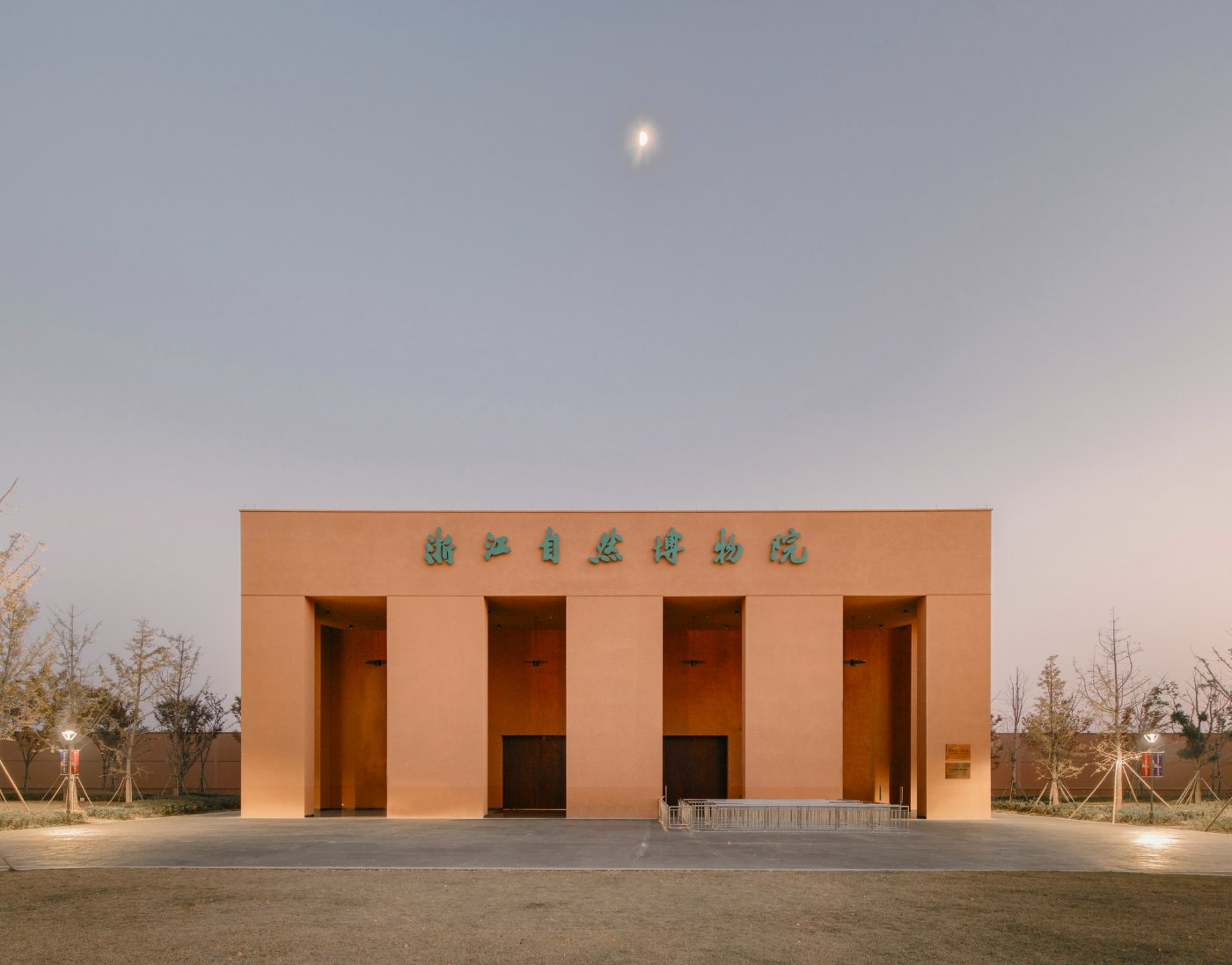 Zhejiang Museum of Natural History by David Chipperfield Architects — David Chipperfield's Zhejiang Museum of Natural History presents itself as a monolithic rendered concrete portal, its warm terracotta facade bifurcated by...