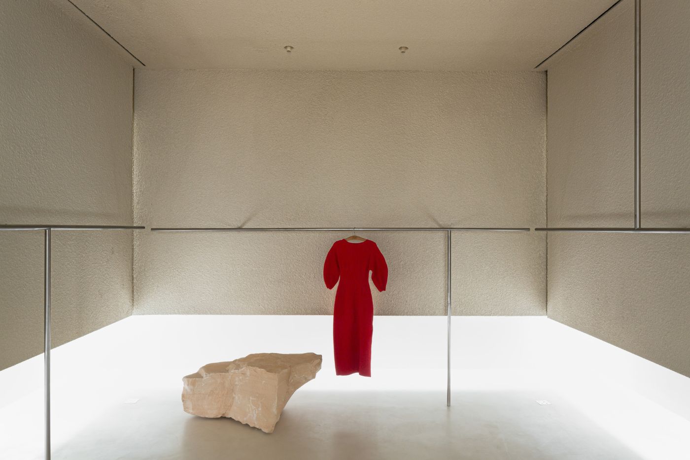 Haight Clothing Store by Entre Terras & Pablo Resende — A minimalist retail display within a rendered plaster gallery space.