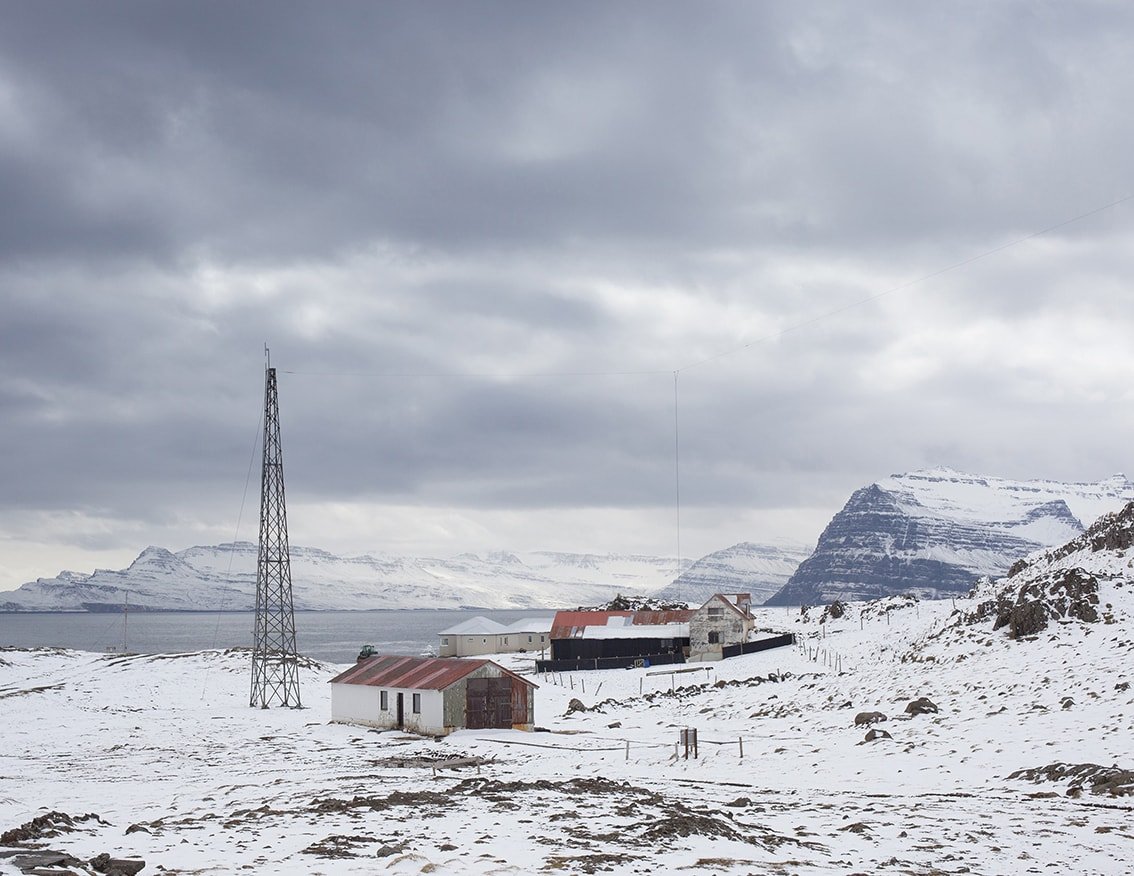 The Weather Report by Marzena Skubatz — A weather station compound occupies the snow-covered terrain of Marsibil, Iceland's remote monitoring outpost.