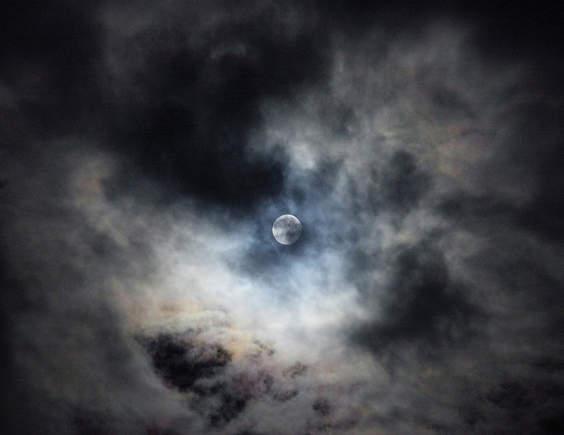The Weather Report by Marzena Skubatz — A full moon emerges through roiling storm clouds above an Icelandic landscape.