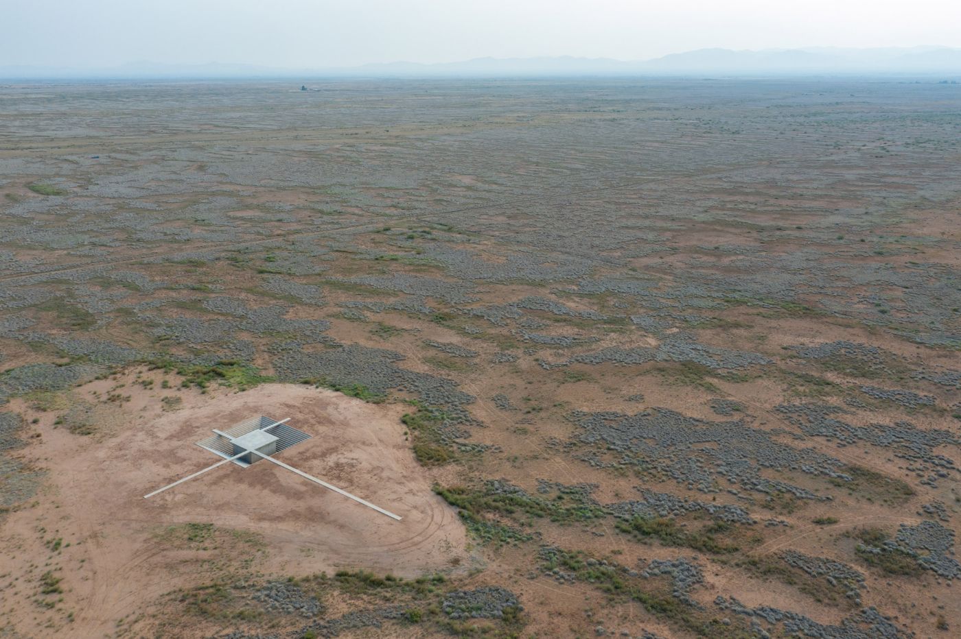 McNeal 020 Pavilion by Atelier David Telerman — Aerial view of McNeal 020 Pavilion situated on compacted reddish-brown earth with sparse vegetation coverage.